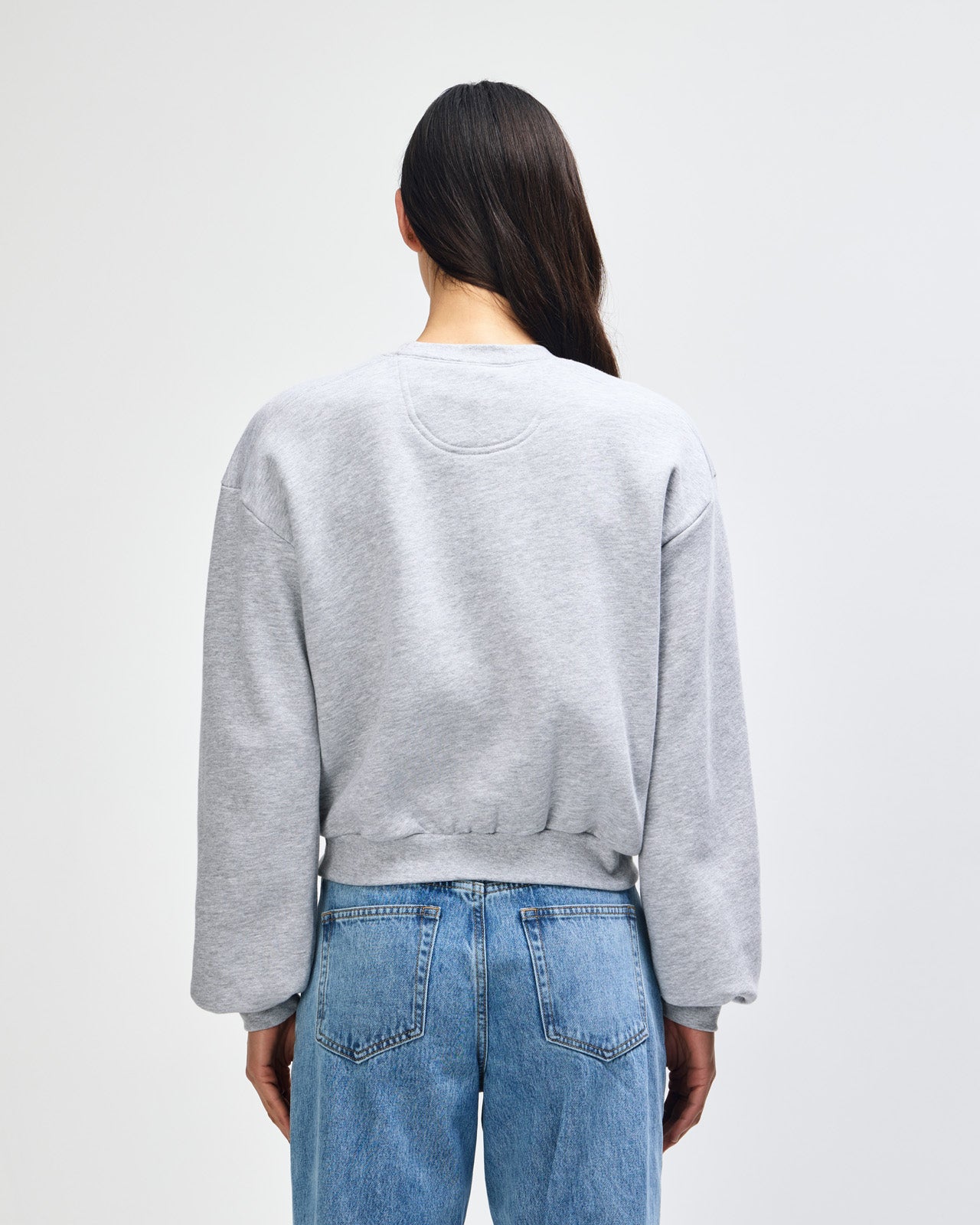 Model wearing a heather grey colour sweatshirt pairing with blue jeans (back pose) -heather grey