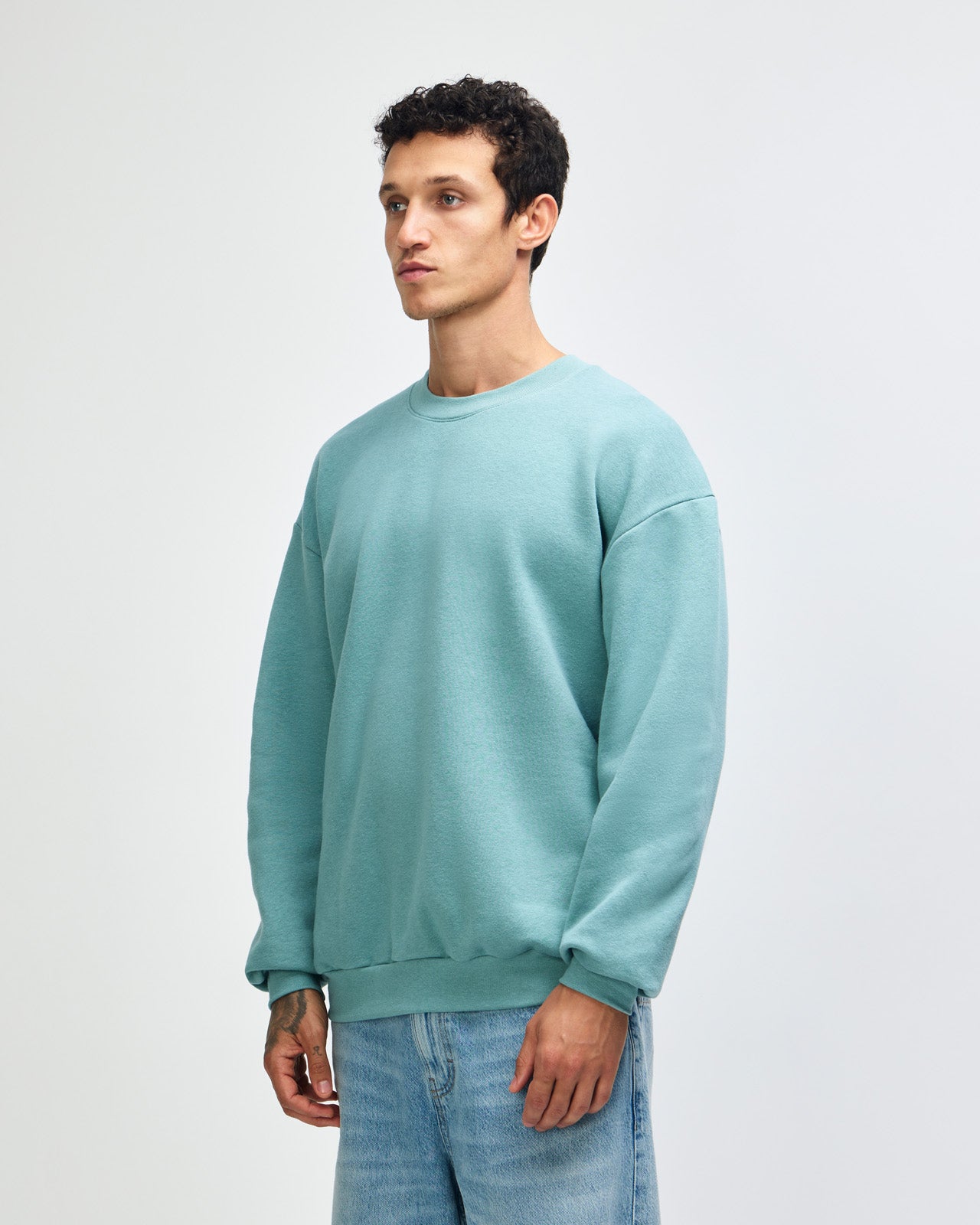 Male model wearing a Reflex Unisex Crewneck Sweatshirt (front pose) -arctic
