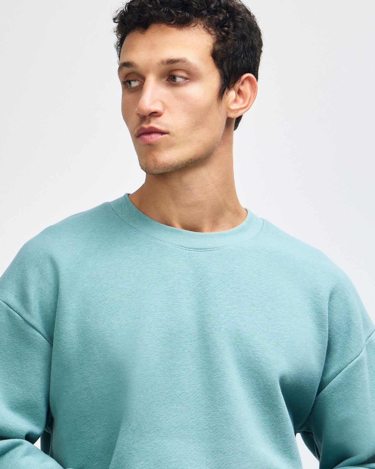 Male model wearing a Reflex Unisex Crewneck Sweatshirt (front pose) -arctic