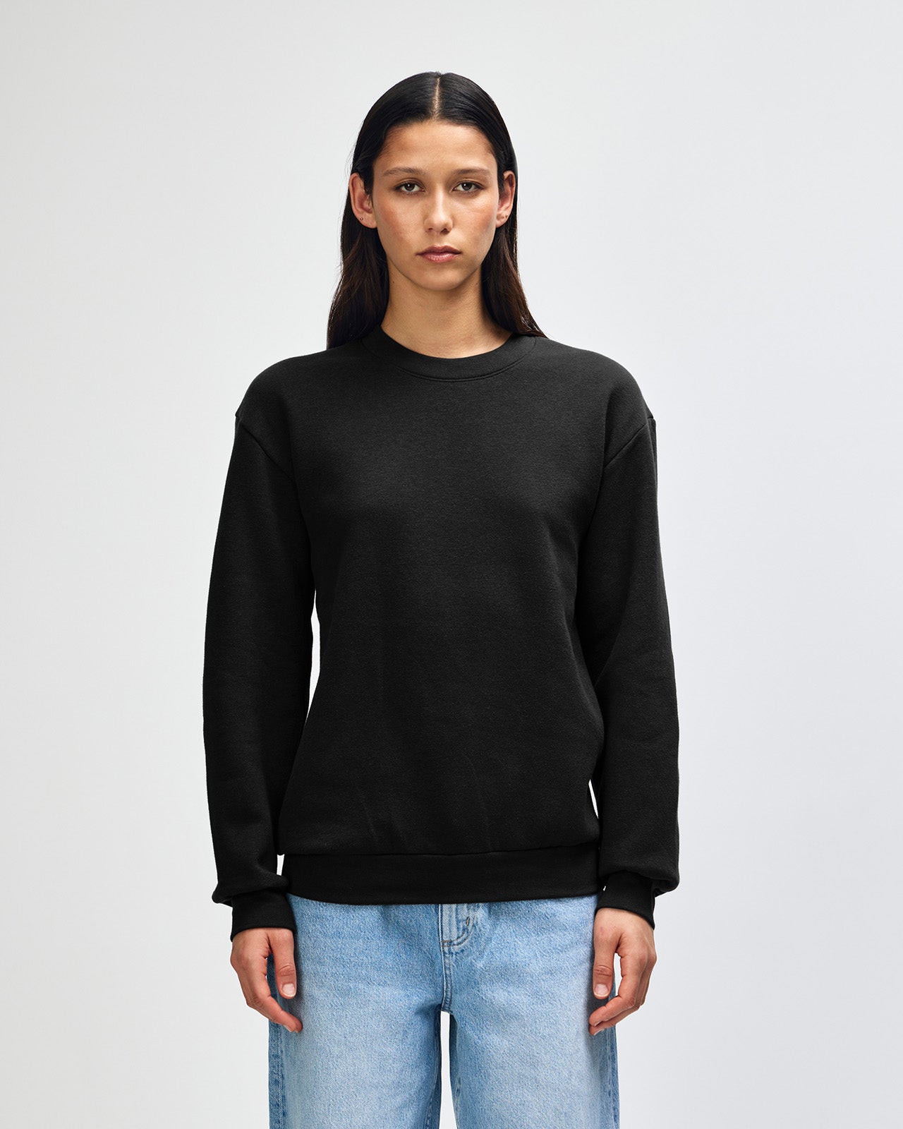Female model wearing a Reflex Unisex Crewneck Sweatshirt (front pose) -black