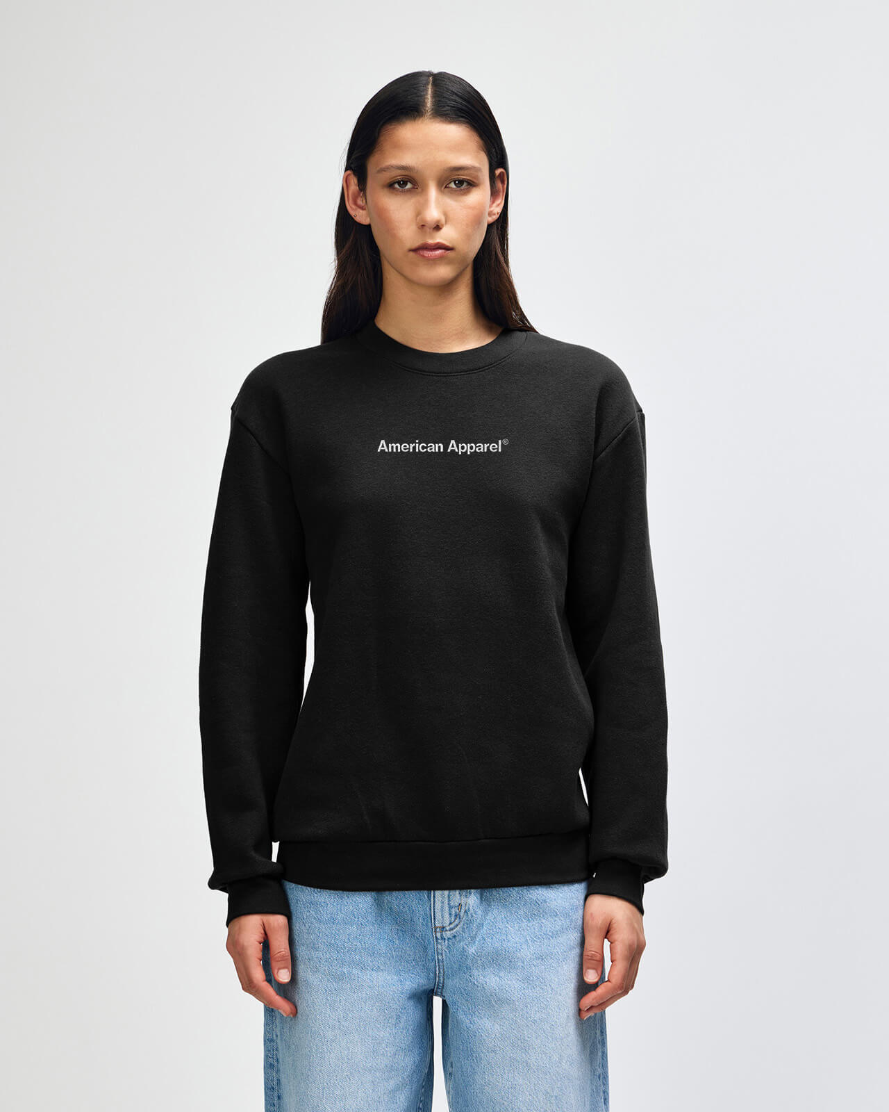 Person wearing a black American Apparel sweatshirt on a light gray background -black