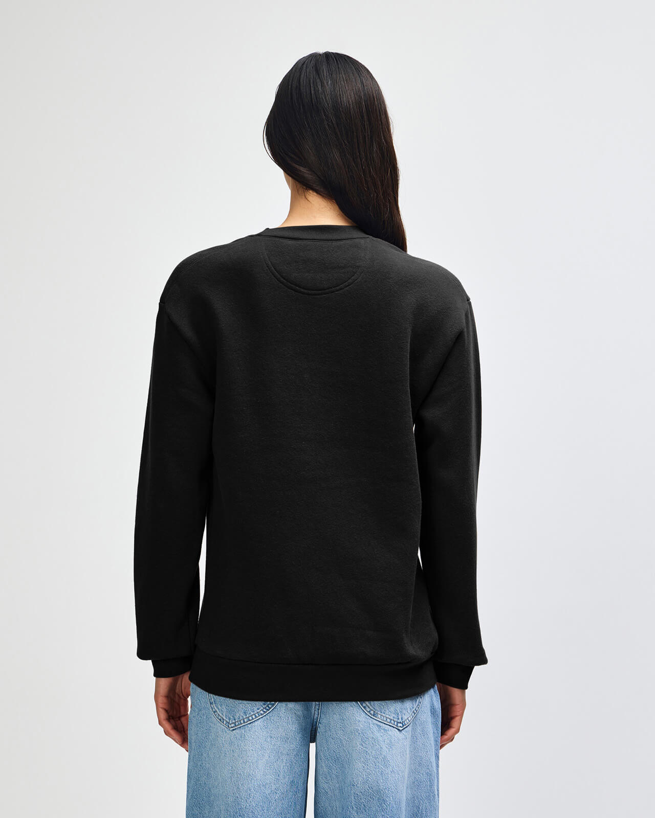 Person wearing a black sweatshirt with a plain background -black