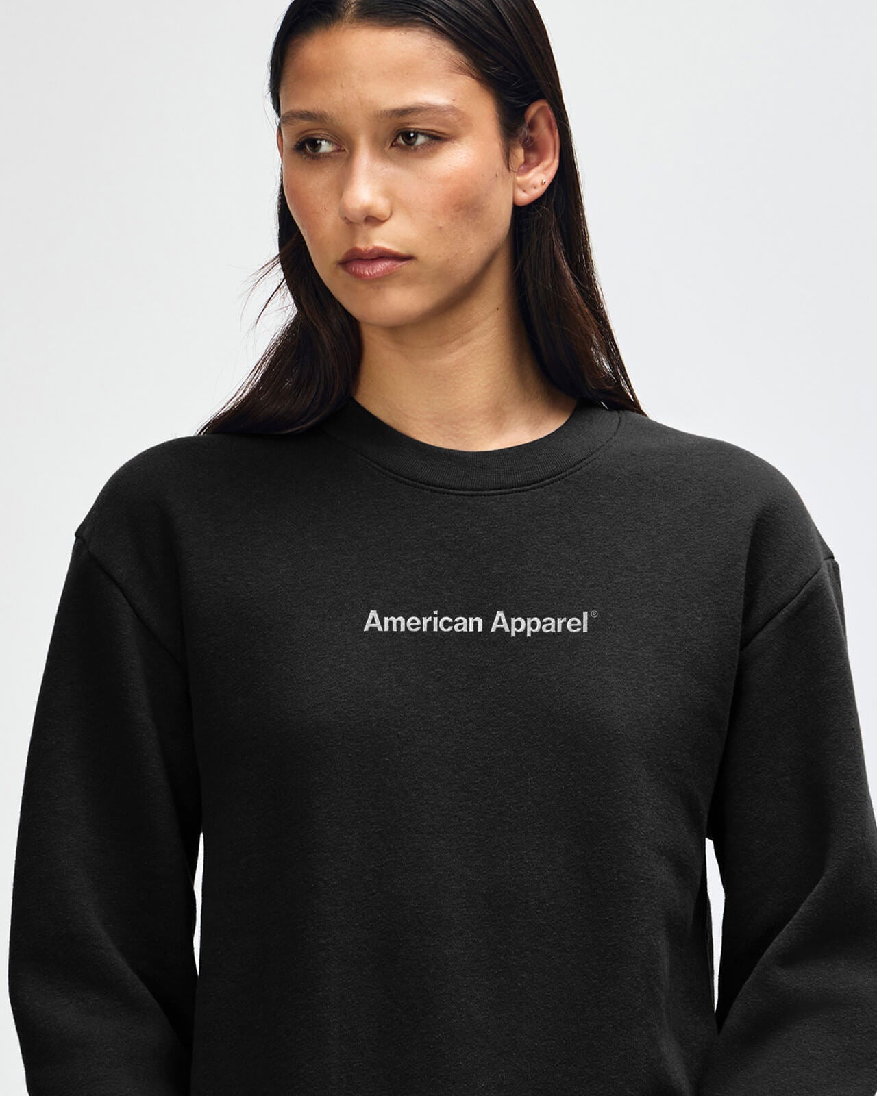 Person wearing a black American Apparel sweatshirt on a plain background -black