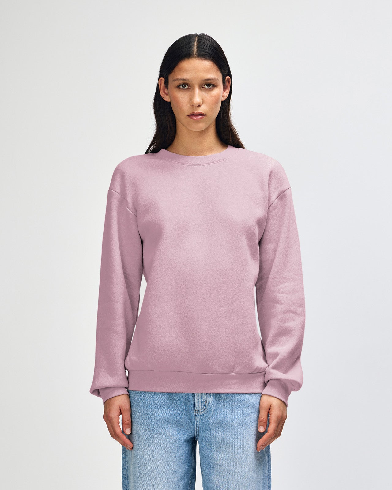 Female model wearing a Reflex Unisex Crewneck Sweatshirt (front pose) -blush