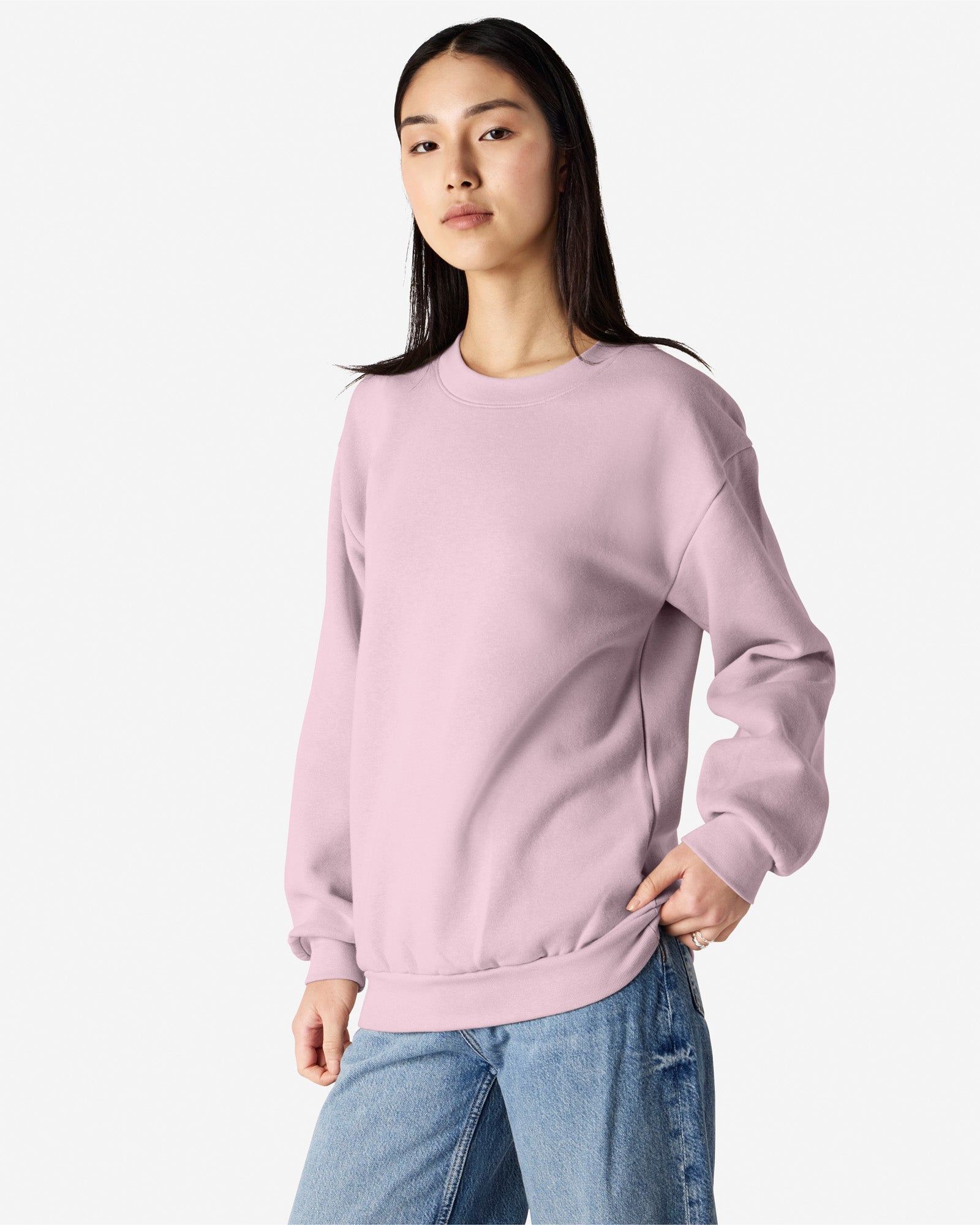 Female model wearing a Reflex Unisex Crewneck Sweatshirt (front side pose) -blush