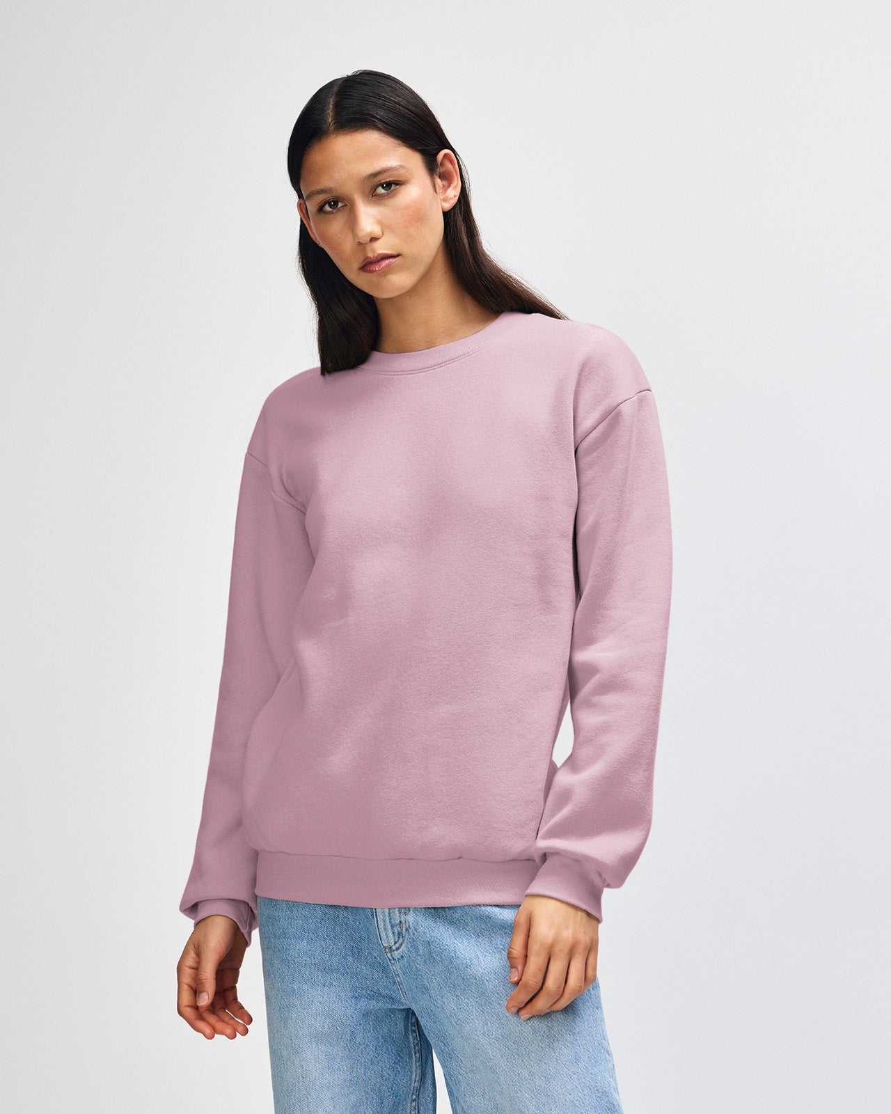 Female model wearing a Reflex Unisex Crewneck Sweatshirt (front pose) -blush