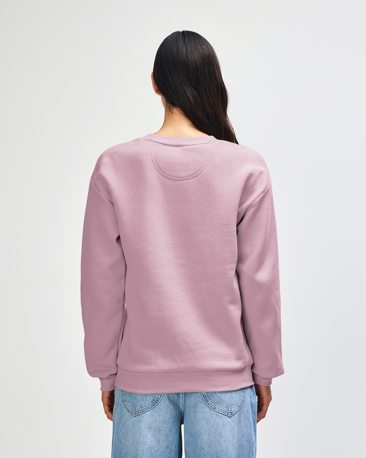 Female model wearing a Reflex Unisex Crewneck Sweatshirt (front pose) -blush