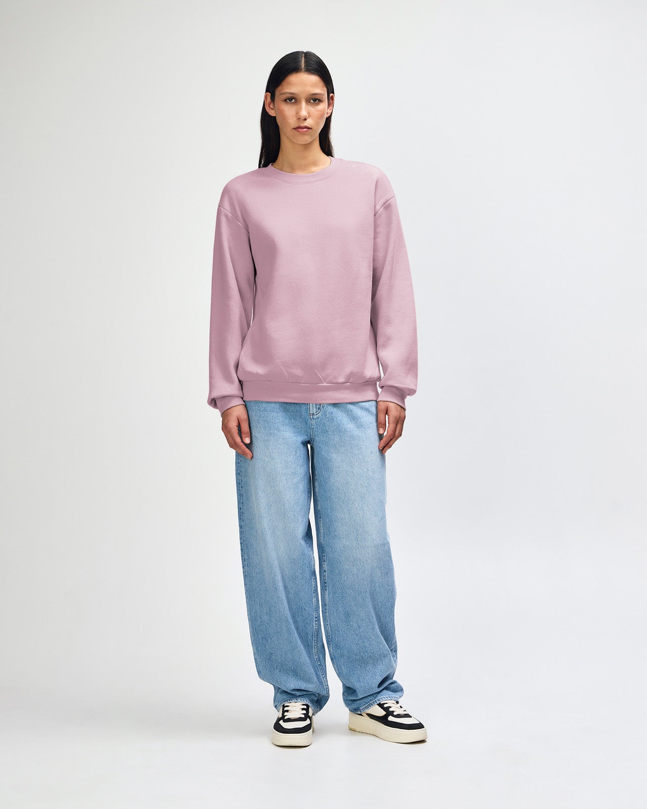 Female model wearing a Reflex Unisex Crewneck Sweatshirt (front pose) -blush