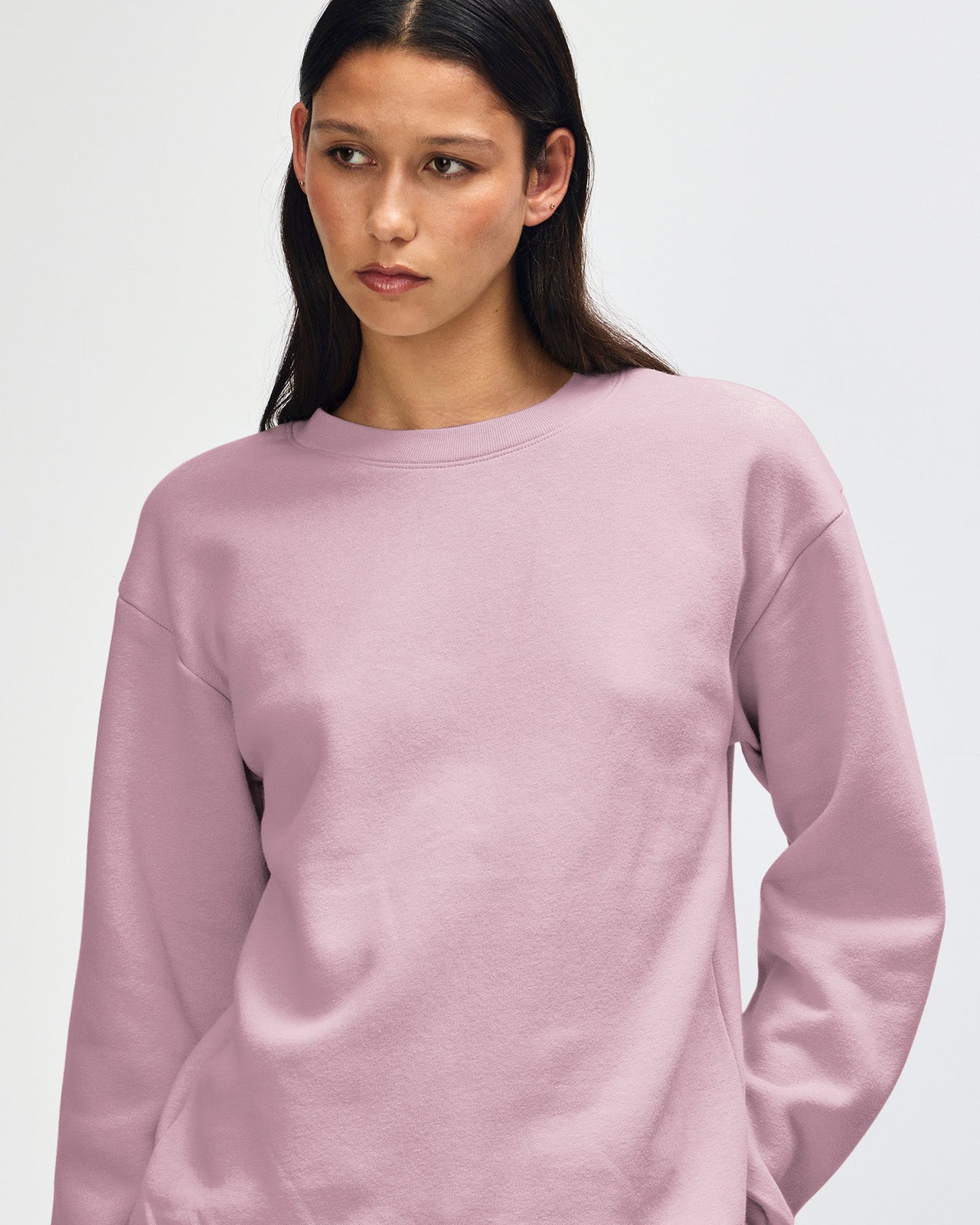 Female model wearing a Reflex Unisex Crewneck Sweatshirt (front pose) -blush