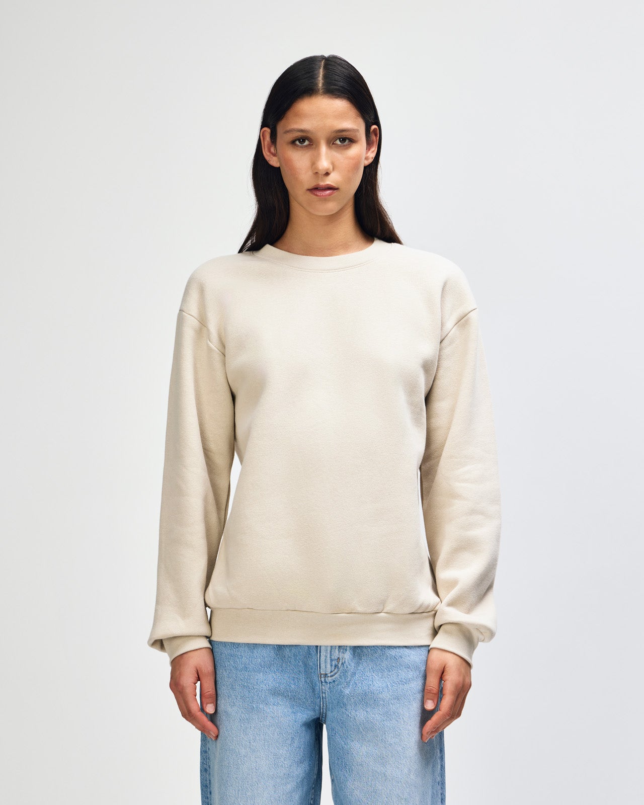 Female model wearing a Reflex Unisex Crewneck Sweatshirt (front pose) -bone