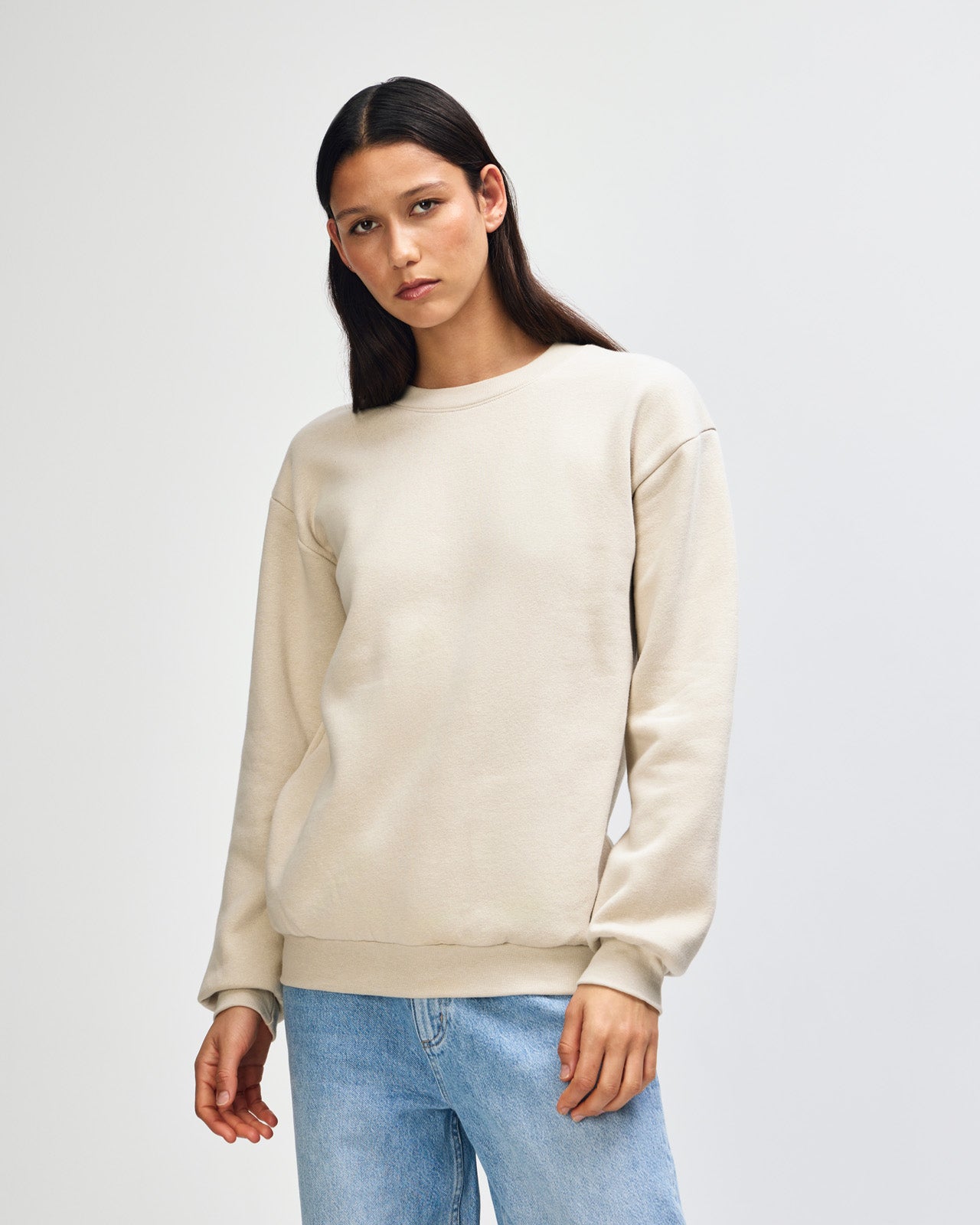 Female model wearing a Reflex Unisex Crewneck Sweatshirt (front pose) -bone