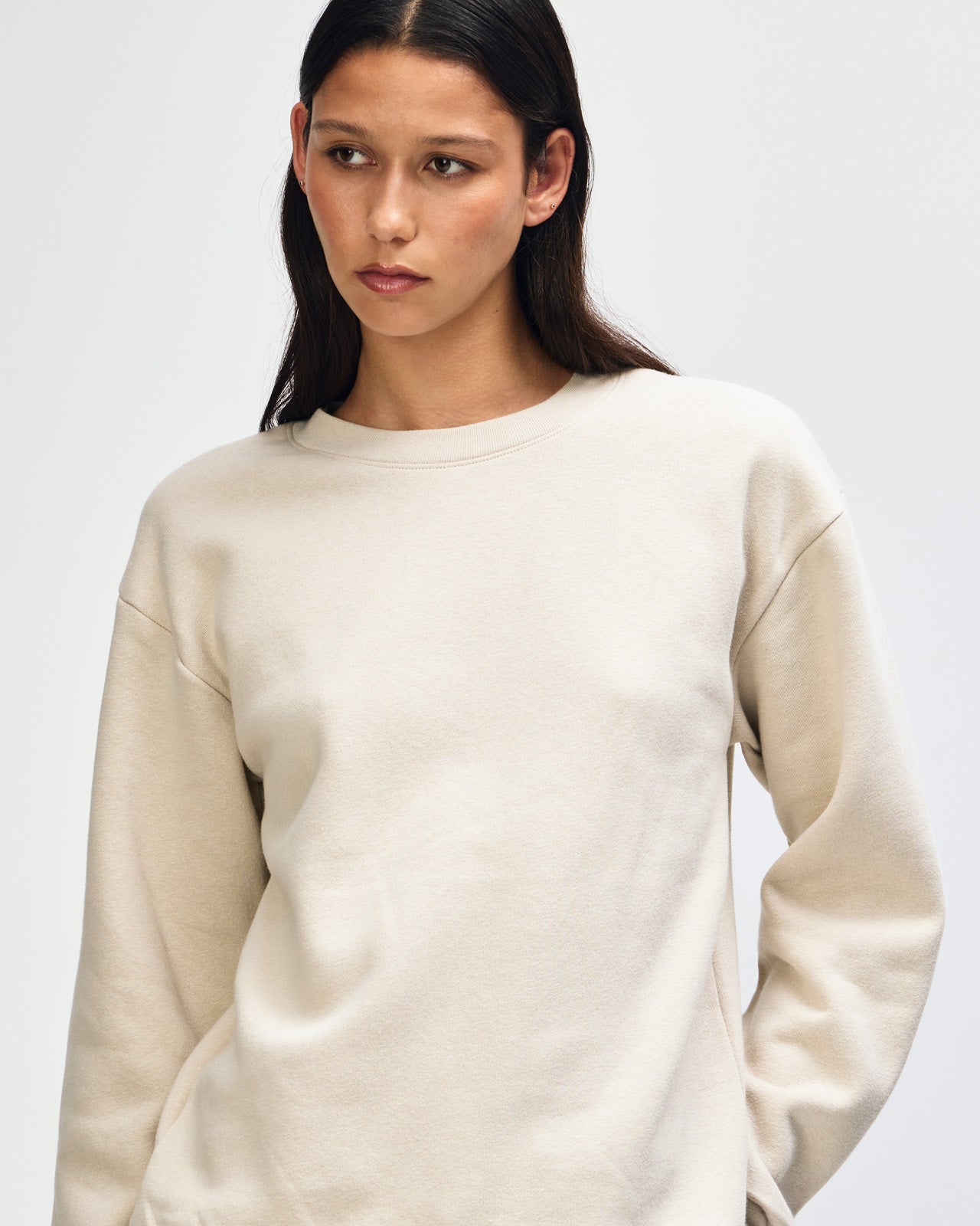 Female model wearing a Reflex Unisex Crewneck Sweatshirt (front pose) -bone