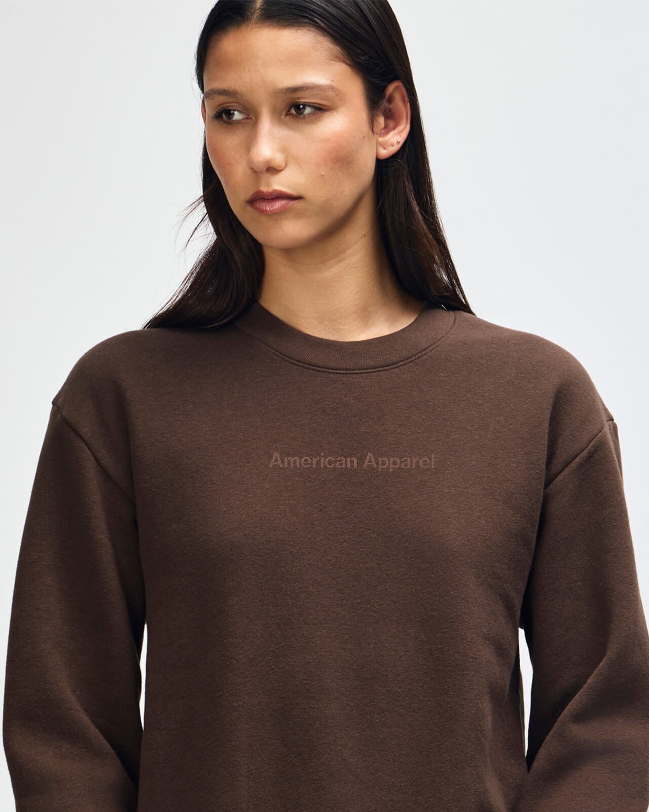 Person wearing a brown American Apparel sweatshirt on a plain background -brown