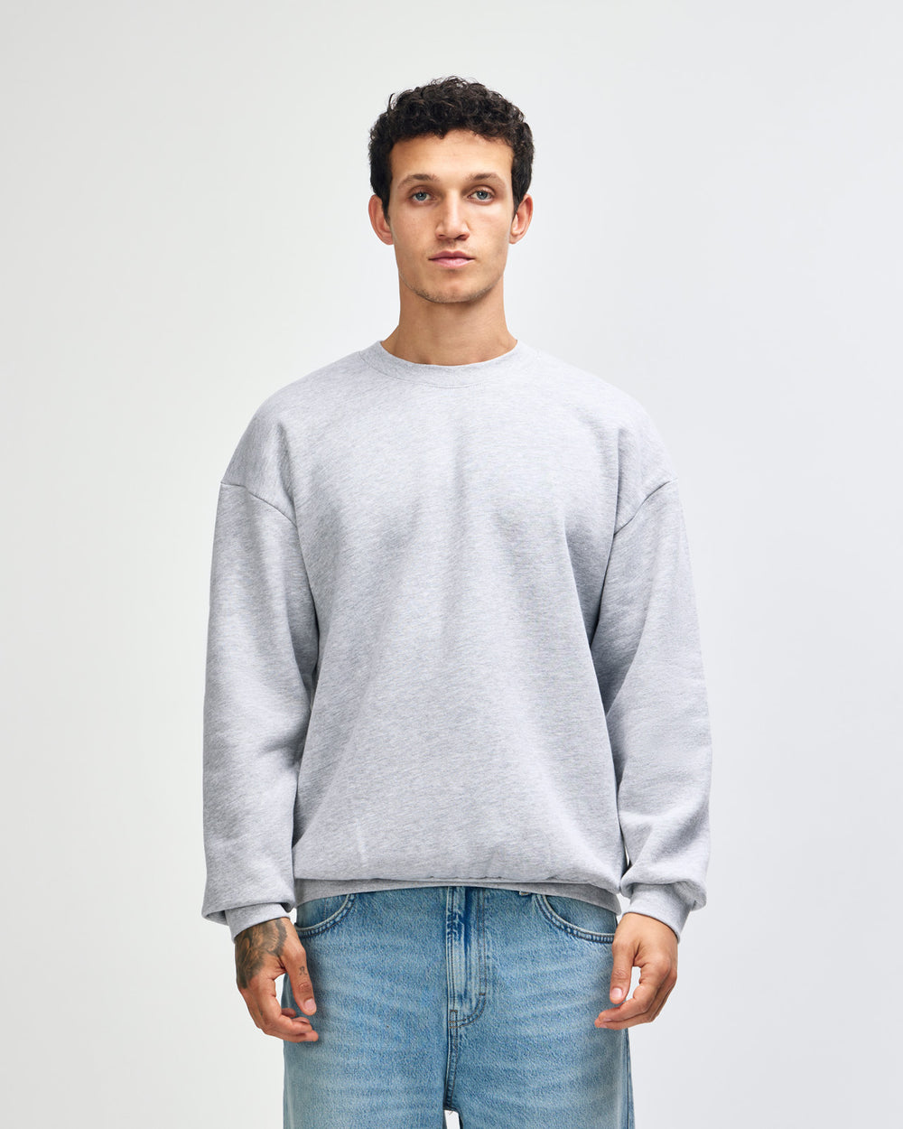 next image of Unisex Sweatshirt : Male model wearing a Reflex Unisex Crewneck Sweatshirt (front pose) -heather grey