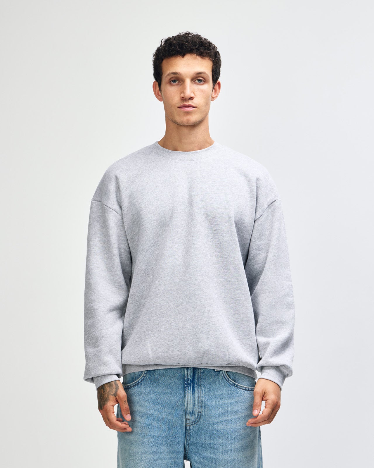 Male model wearing a Reflex Unisex Crewneck Sweatshirt (front pose) -heather grey