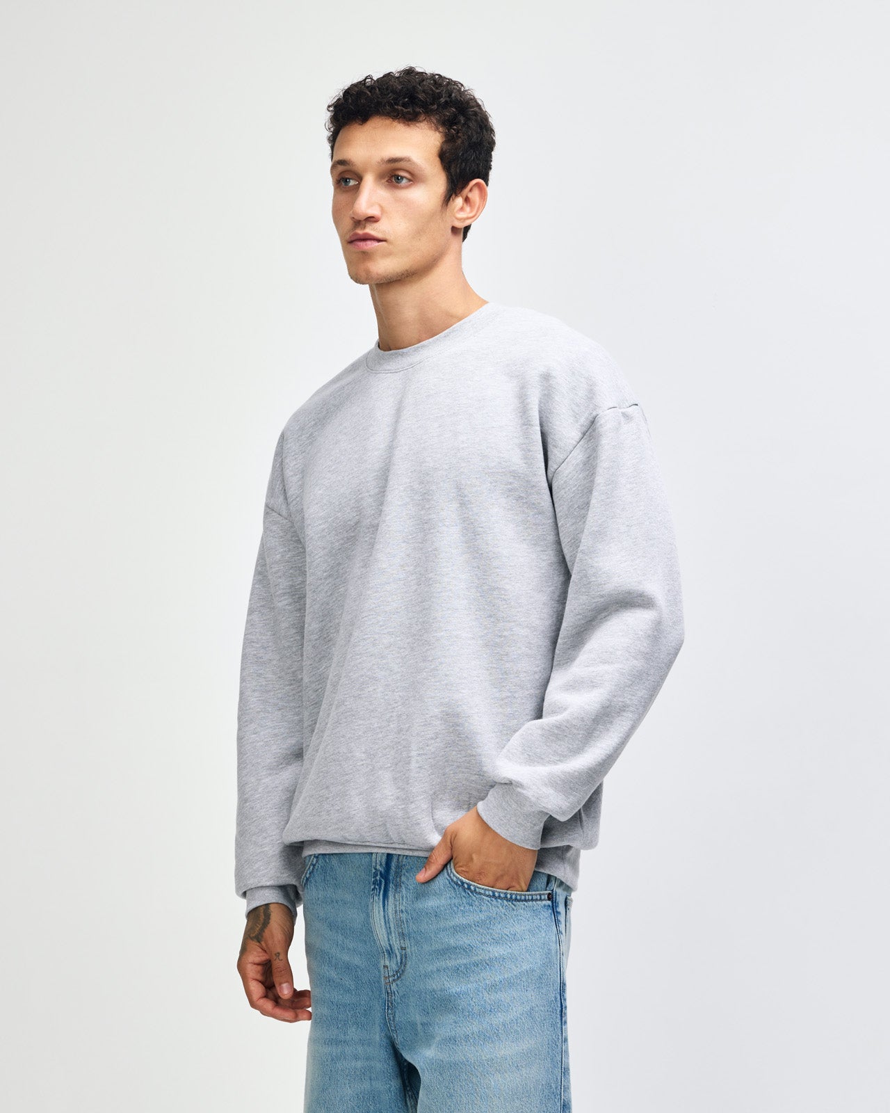 Male model wearing a Reflex Unisex Crewneck Sweatshirt (front pose) -heather grey