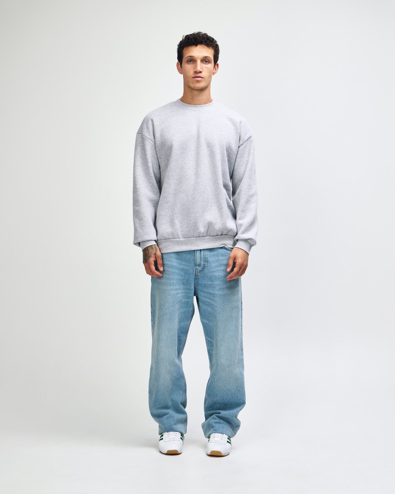 Male model wearing a Reflex Unisex Crewneck Sweatshirt (front pose) -heather grey