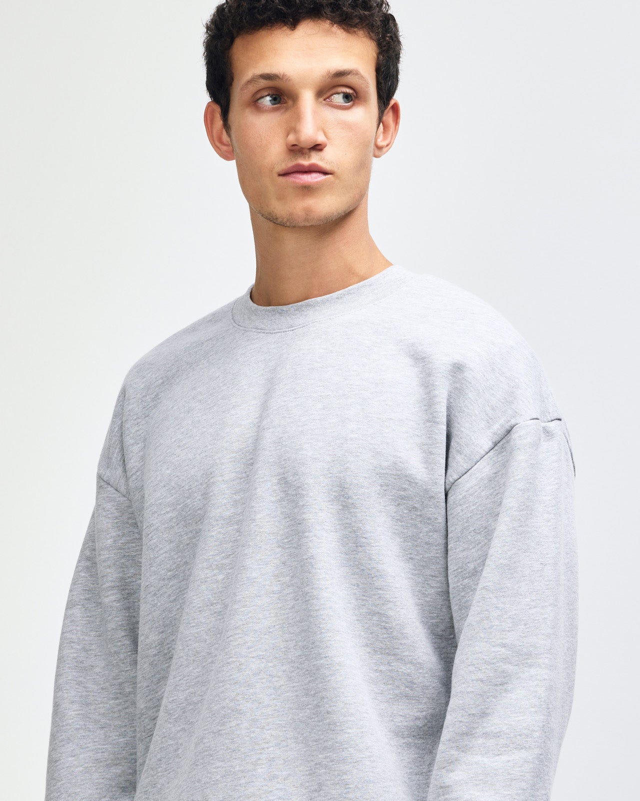 Male model wearing a Reflex Unisex Crewneck Sweatshirt (front pose) -heather grey