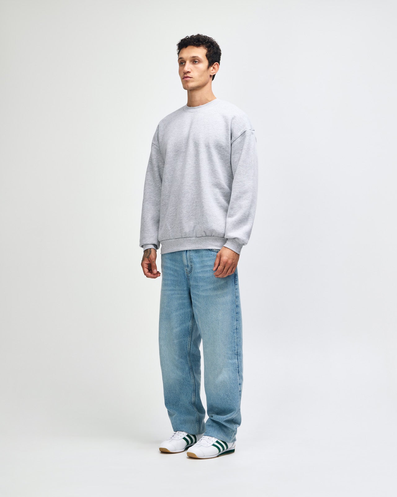 Male model wearing a Reflex Unisex Crewneck Sweatshirt (front pose) -heather grey