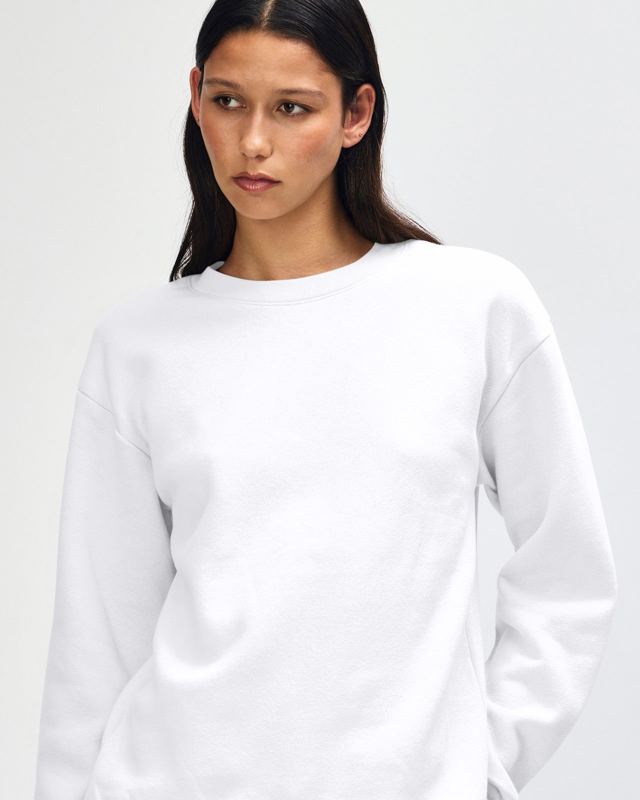 Female model wearing a Reflex Unisex Crewneck Sweatshirt (front pose) -white