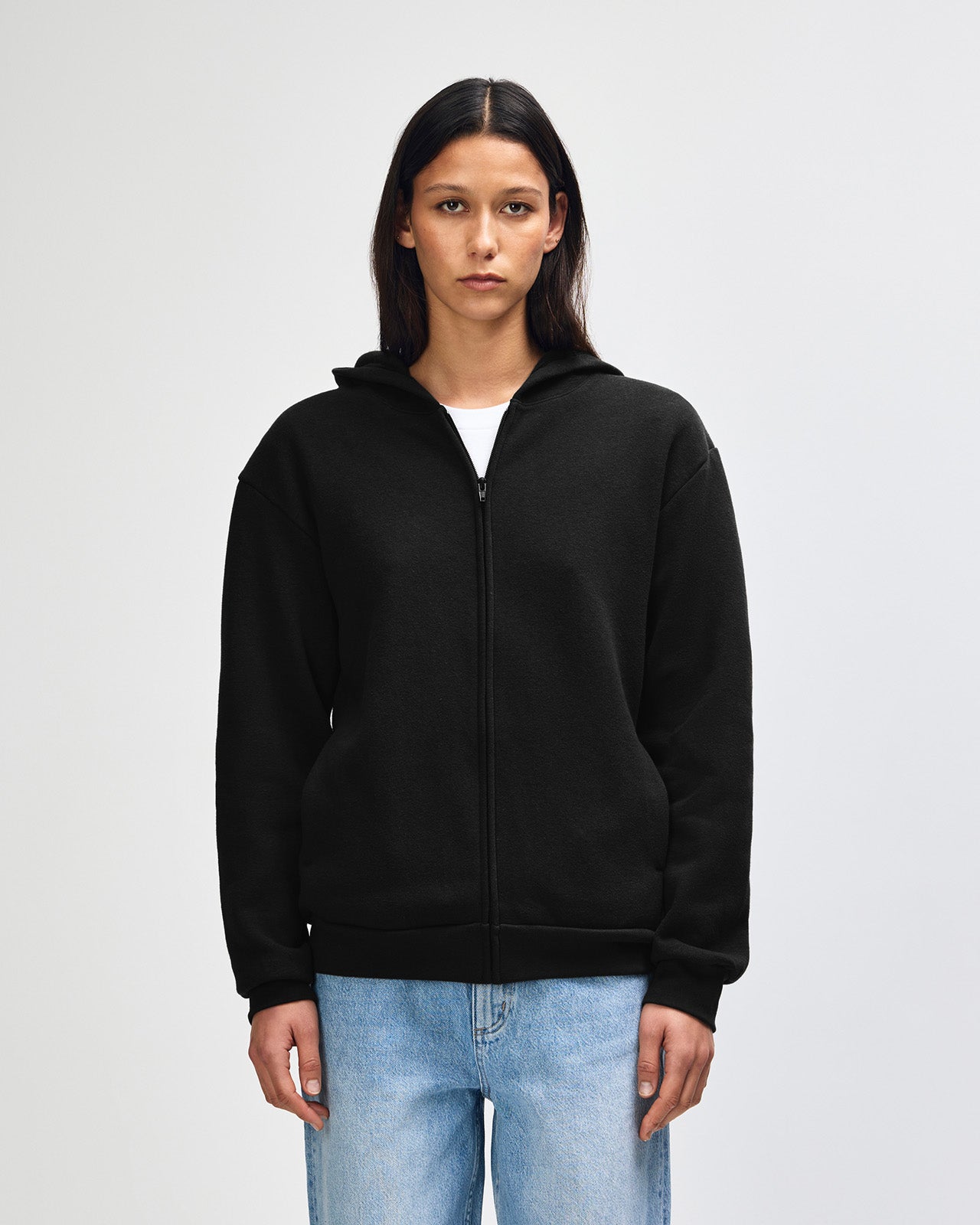 Female model wearing Reflex Unisex Full Zip Hooded Sweatshirt pairing with blue jeans (front pose) -black