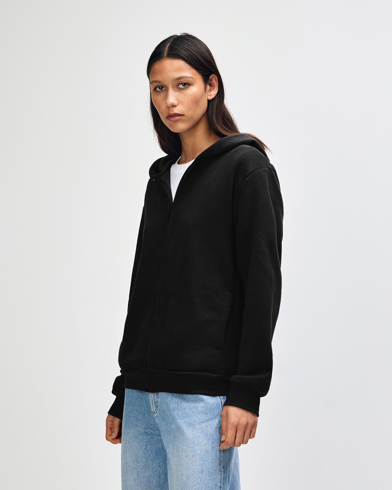 Female model wearing Reflex Unisex Full Zip Hooded Sweatshirt pairing with blue jeans (front pose) -black
