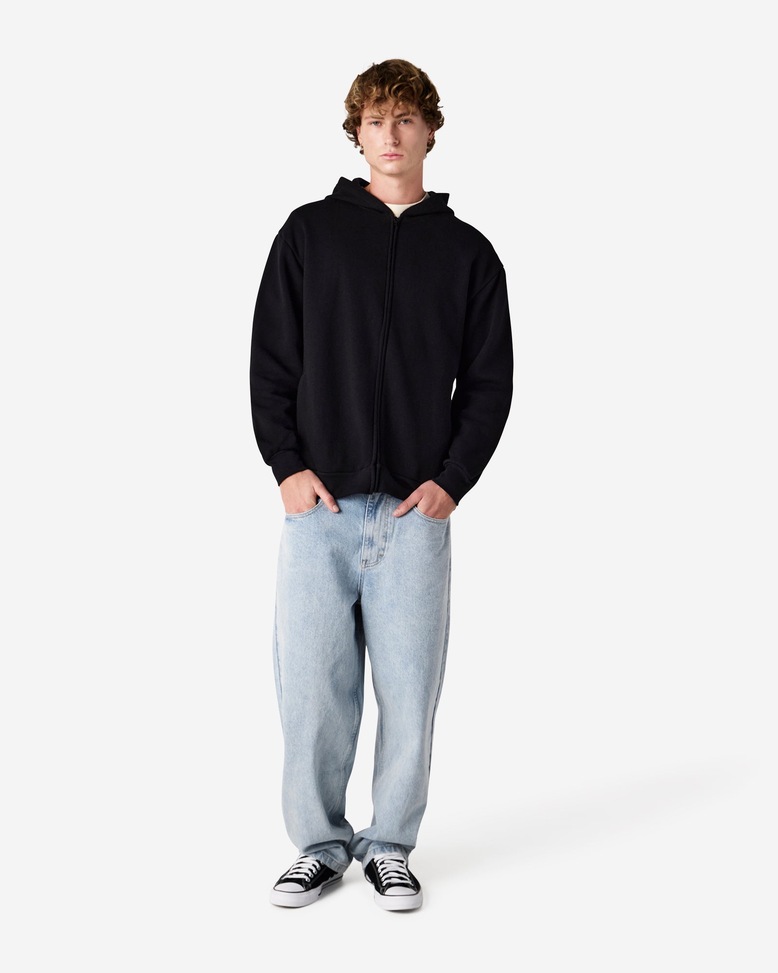 Male model wearing Reflex Unisex Full Zip Hooded Sweatshirt pairing with blue jeans (front pose) -black