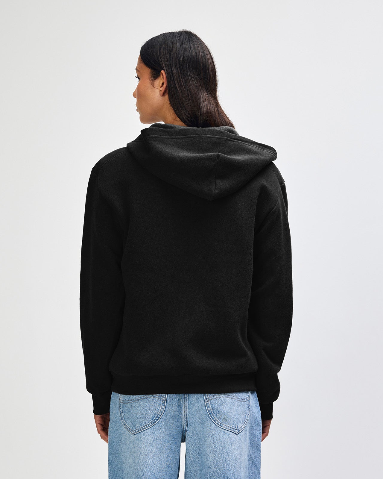 Female model wearing Reflex Unisex Full Zip Hooded Sweatshirt pairing with blue jeans (back pose) -black