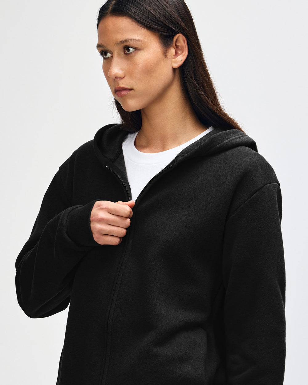 next image of Zip-Up Hoodie Tracksuit - Black : Female model wearing Reflex Unisex Full Zip Hooded Sweatshirt pairing with blue jeans (close up pose) -black