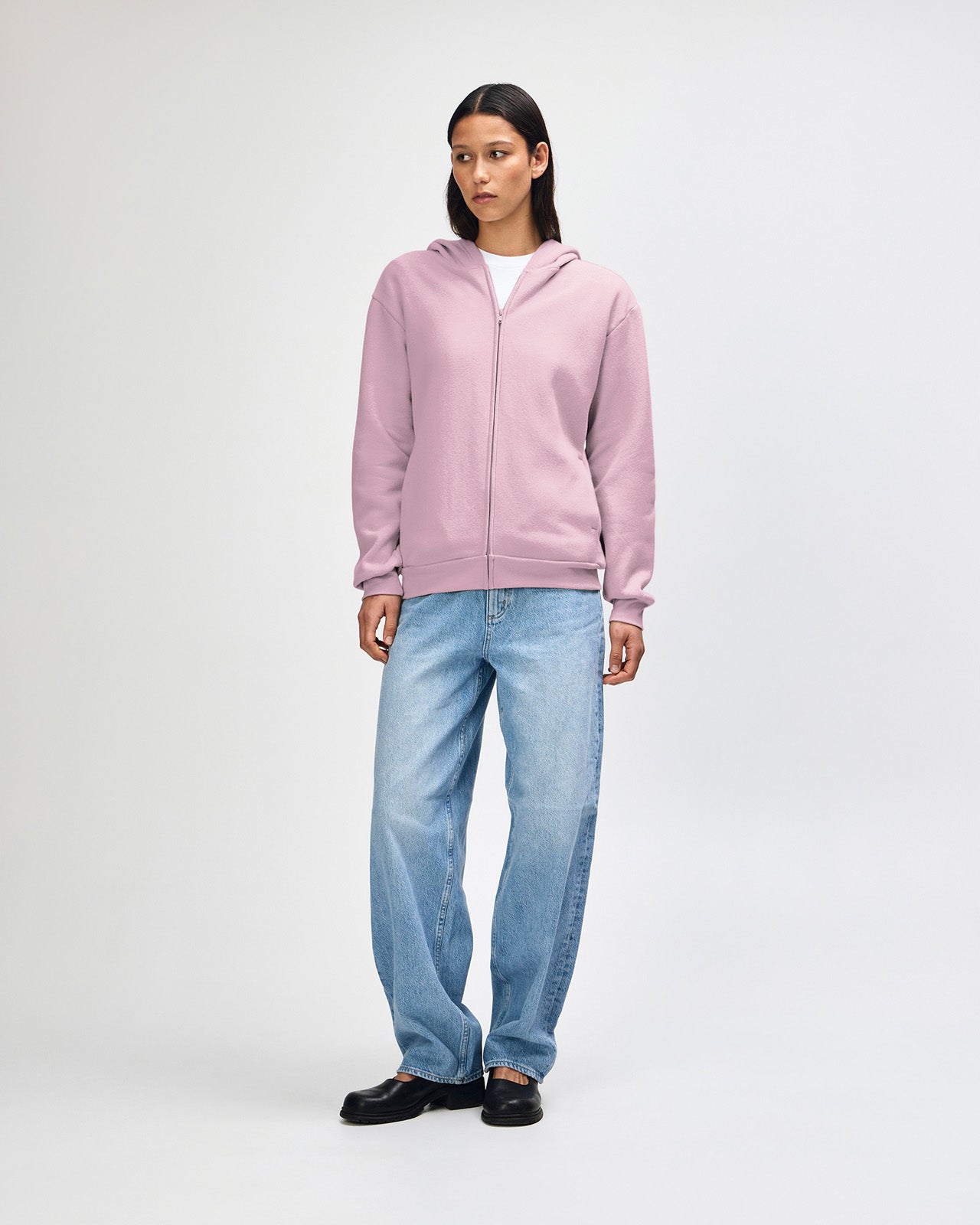Female model wearing Reflex Unisex Full Zip Hooded Sweatshirt pairing with blue jeans (front pose) -blush