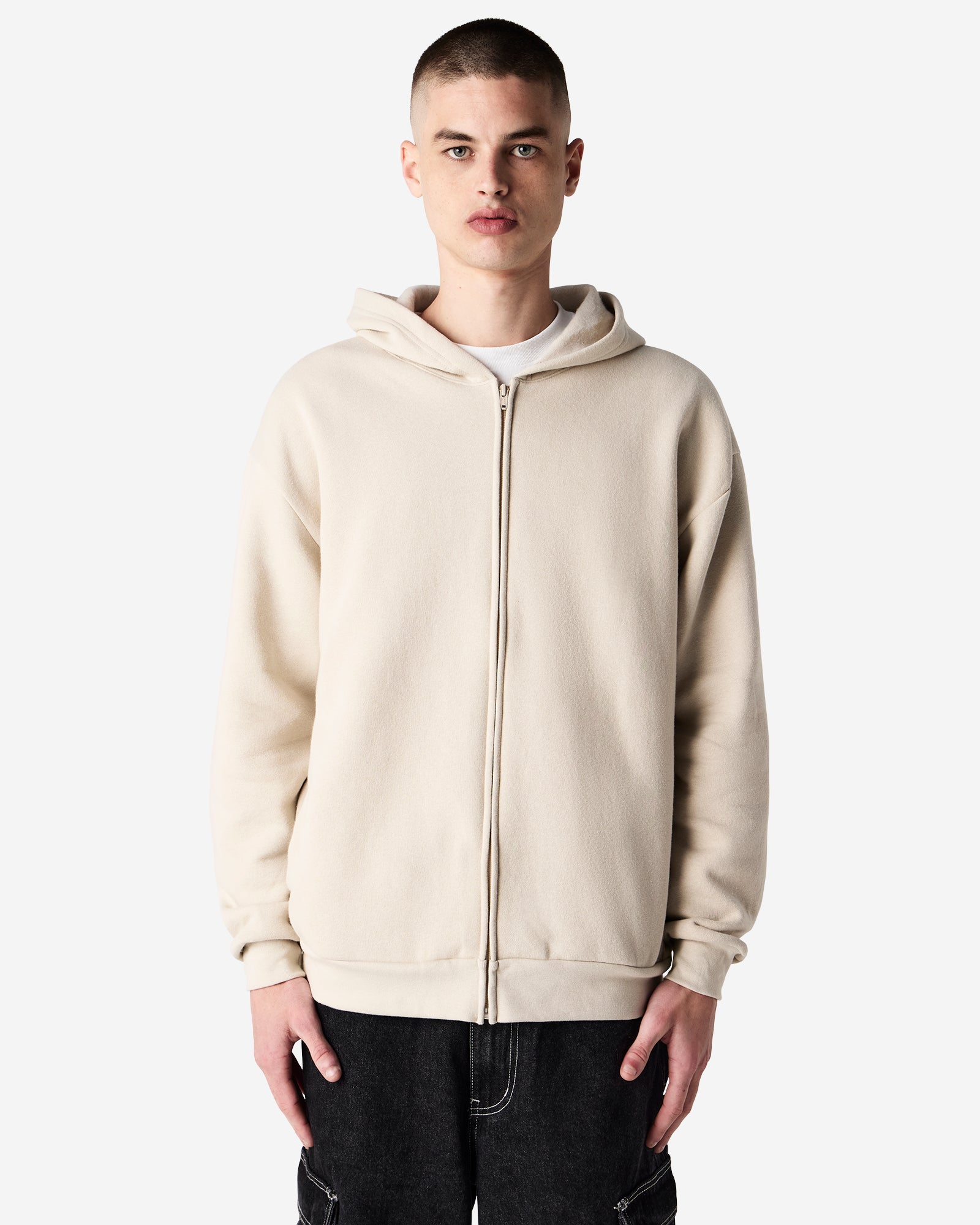 Male model wearing Reflex Unisex Full Zip Hooded Sweatshirt pairing with blue jeans (front pose) -bone