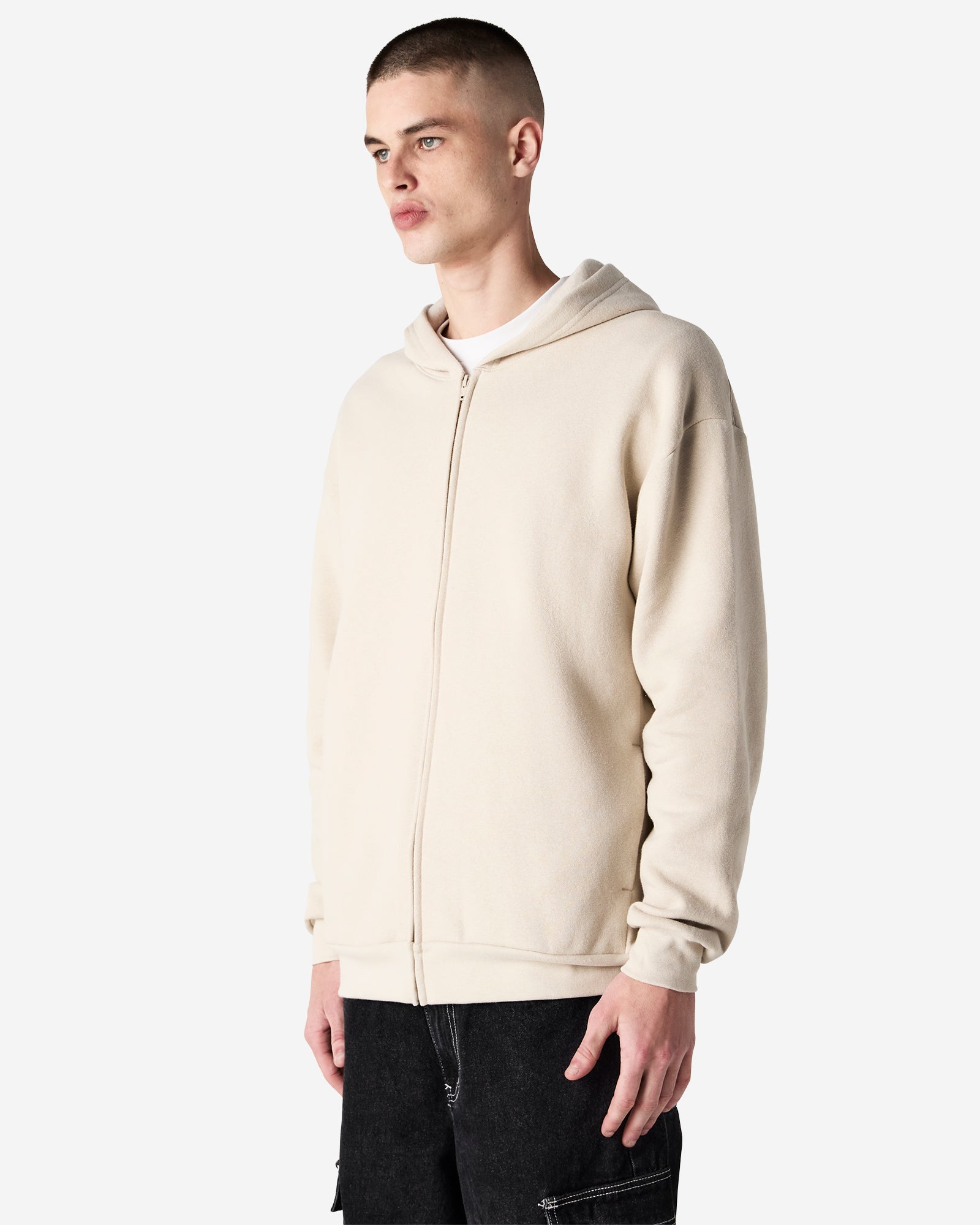 Male model wearing Reflex Unisex Full Zip Hooded Sweatshirt pairing with blue jeans (front pose) -bone