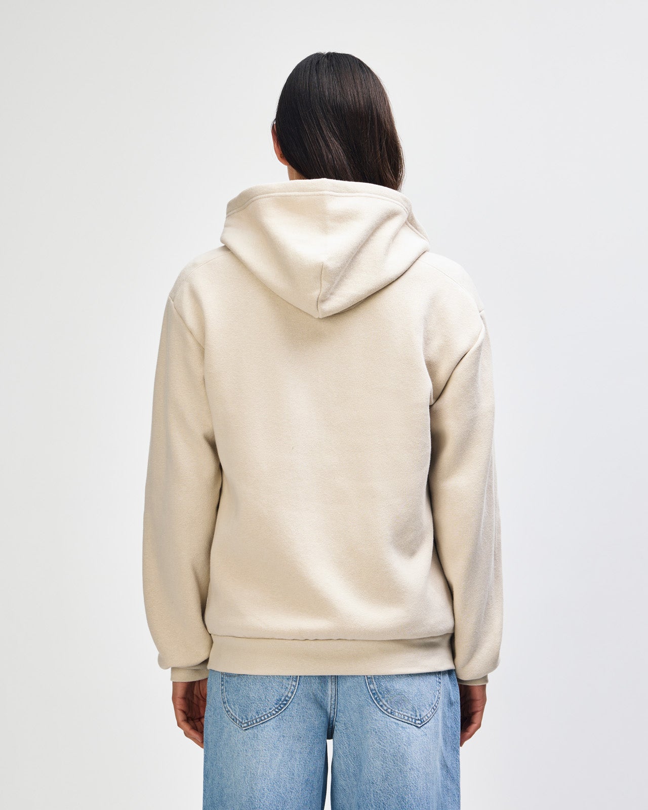Female model wearing Reflex Unisex Full Zip Hooded Sweatshirt pairing with blue jeans (back pose) -bone