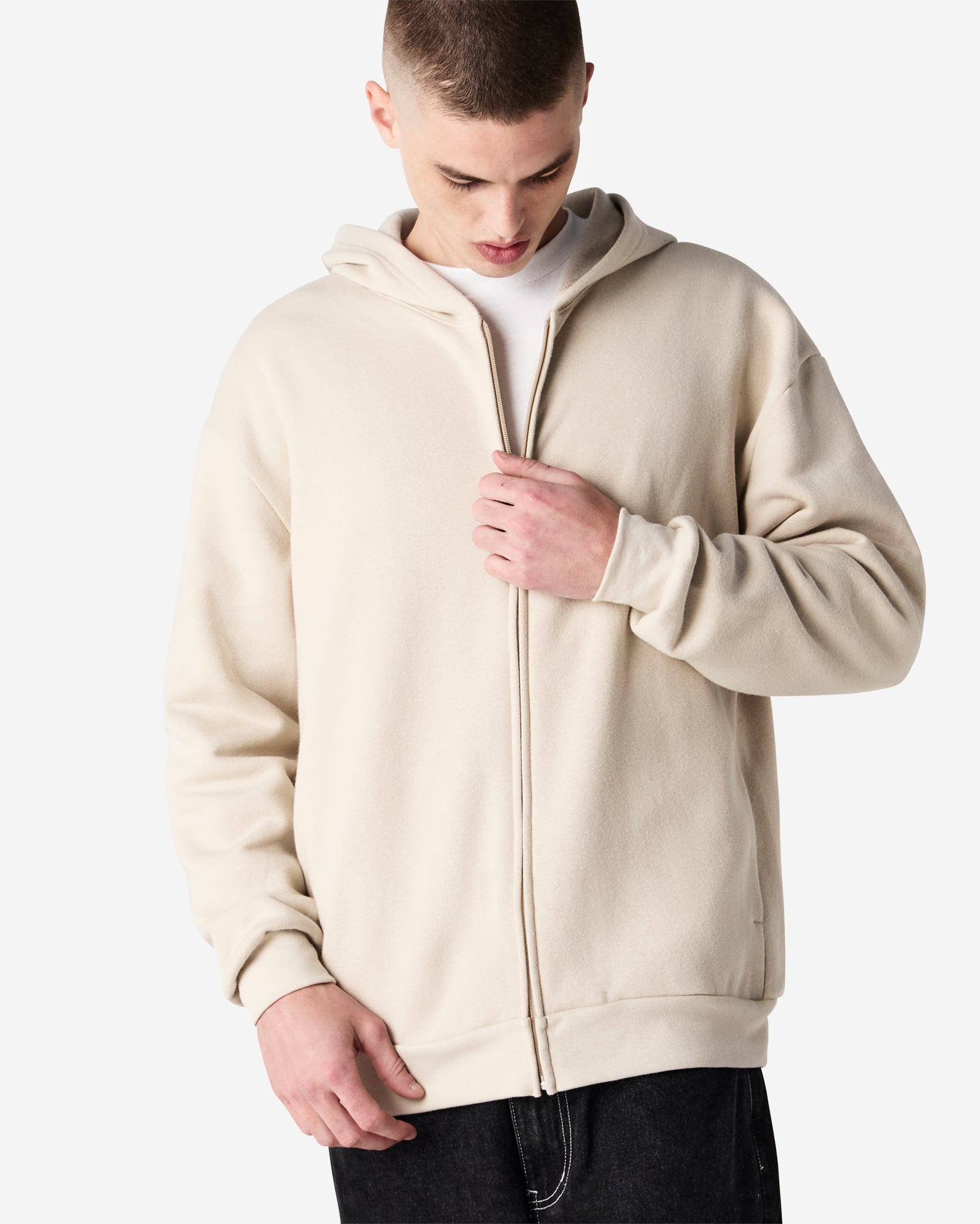 Male model wearing Reflex Unisex Full Zip Hooded Sweatshirt pairing with blue jeans (front pose) -bone