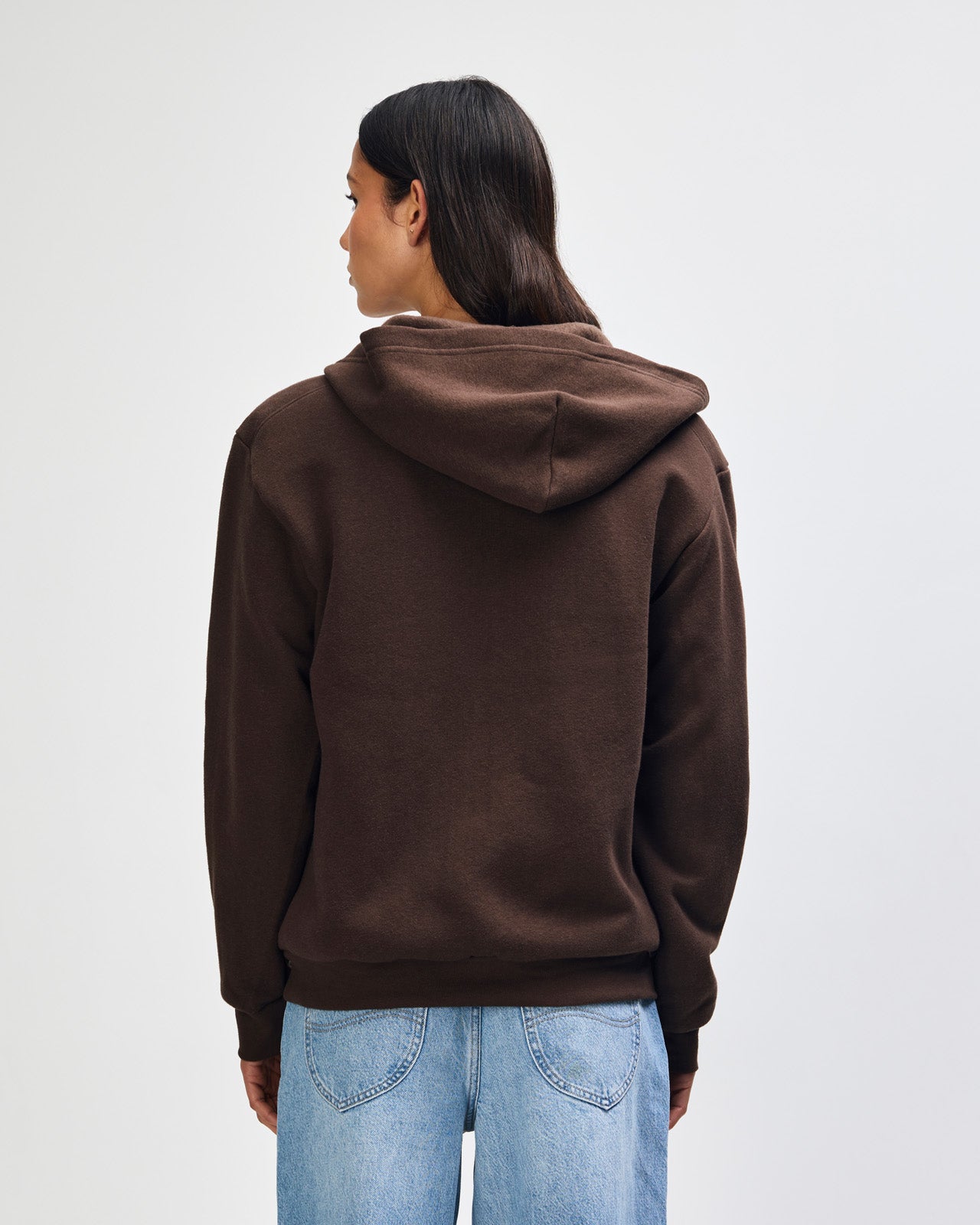 Female model wearing Reflex Unisex Full Zip Hooded Sweatshirt pairing with blue jeans (back pose) -brown