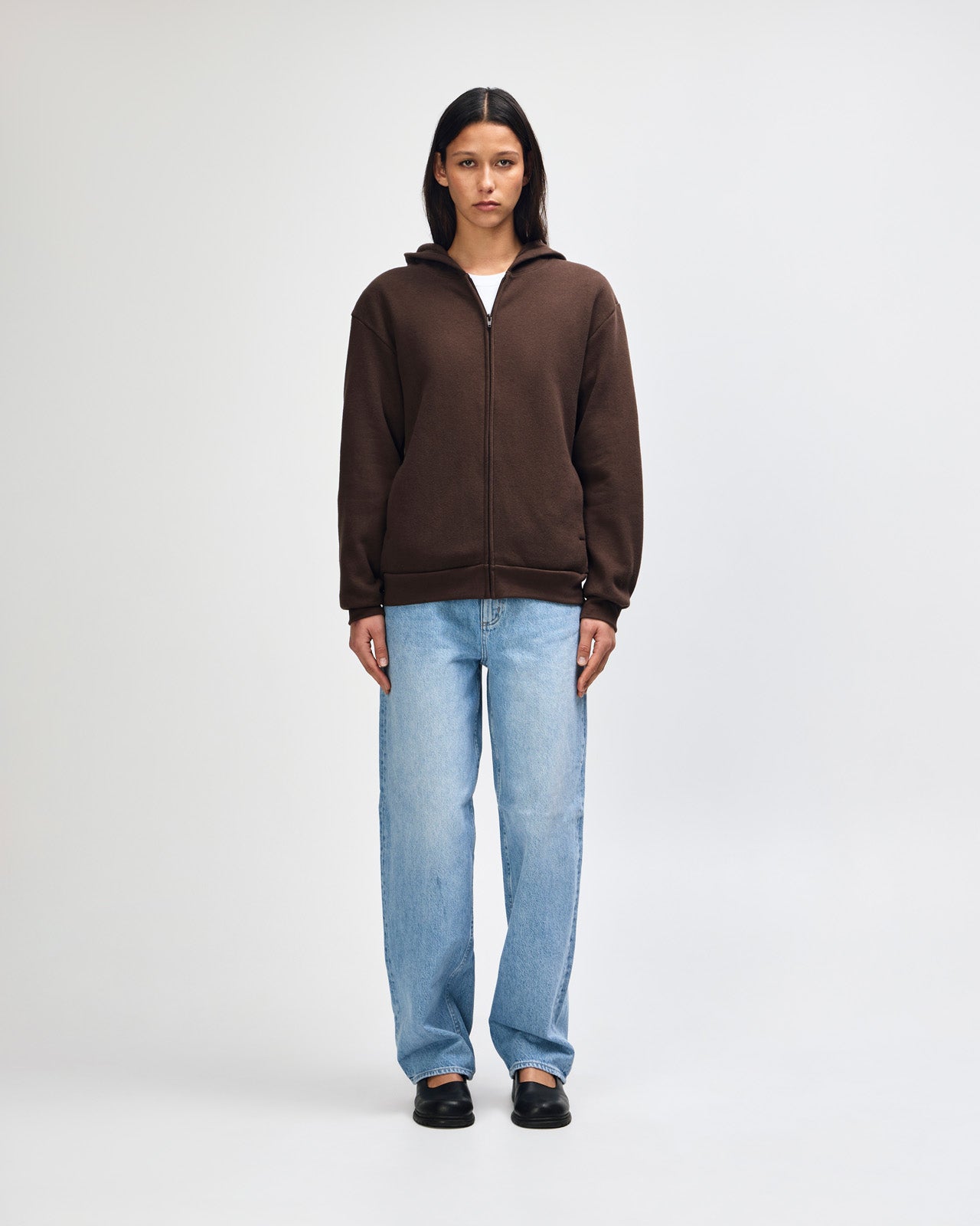 Female model wearing Reflex Unisex Full Zip Hooded Sweatshirt pairing with blue jeans (front pose) -brown