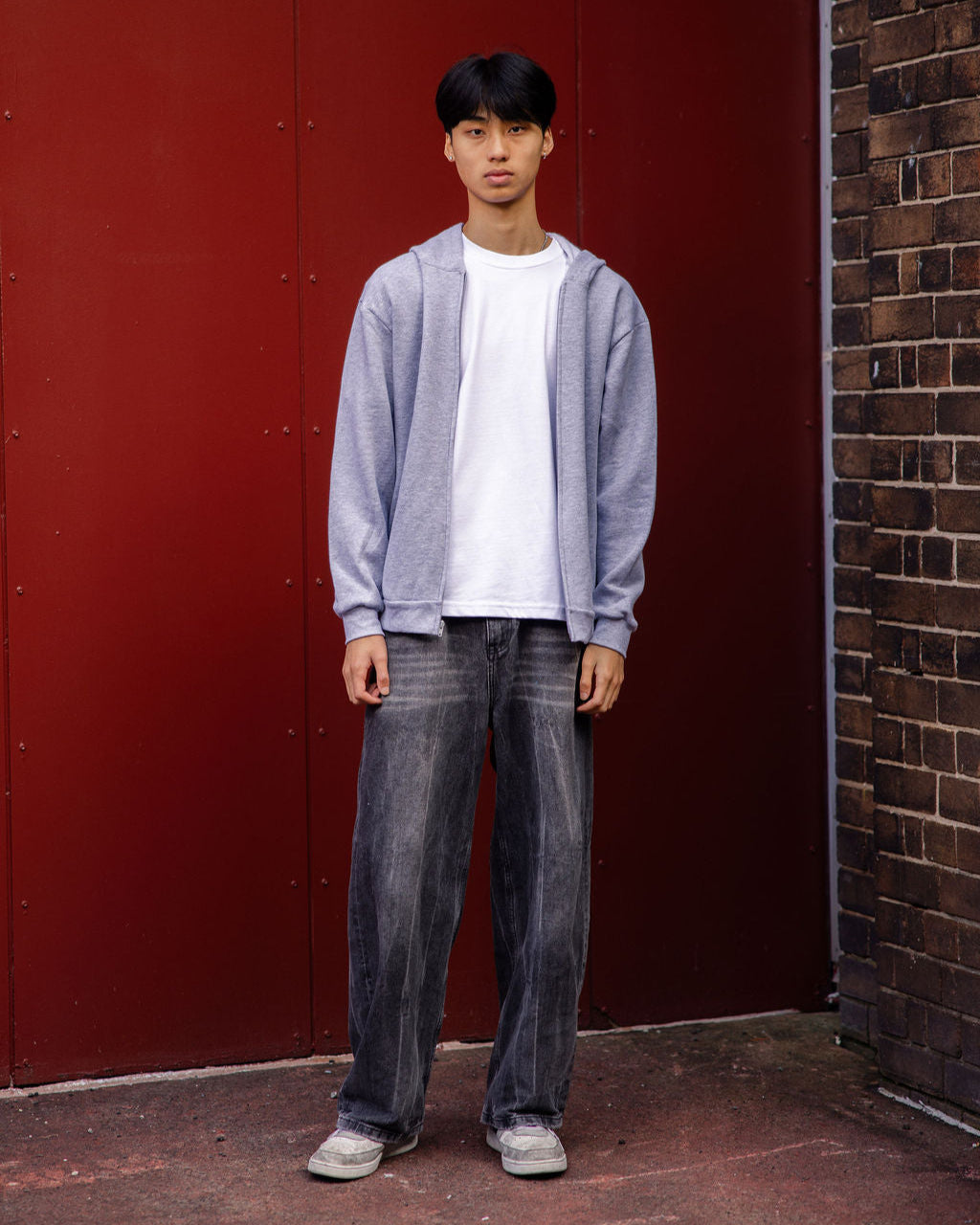 Male model wearing Reflex Unisex Full Zip Hooded Sweatshirt pairing with blue jeans (full length pose) -heather grey