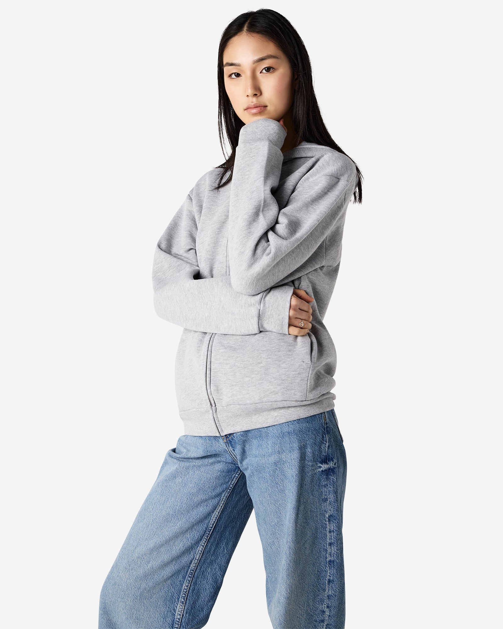 Female model wearing Reflex Unisex Full Zip Hooded Sweatshirt pairing with blue jeans (side pose) -heather grey