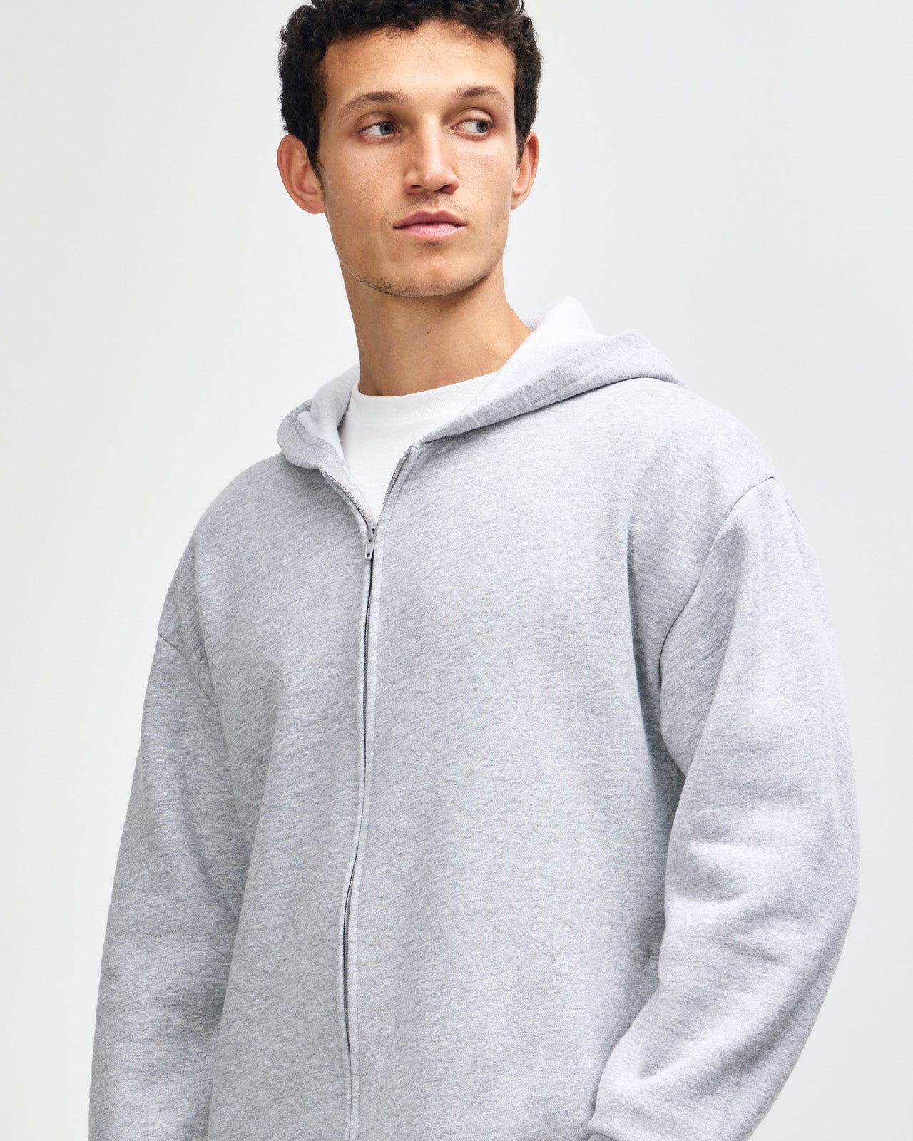 Male model wearing Reflex Unisex Full Zip Hooded Sweatshirt pairing with blue jeans (front pose) - heather grey