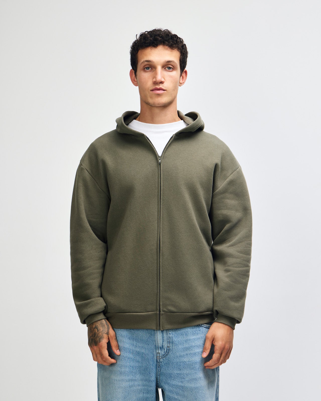 Male model wearing Reflex Unisex Full Zip Hooded Sweatshirt pairing with blue jeans (front pose) - lieutenant