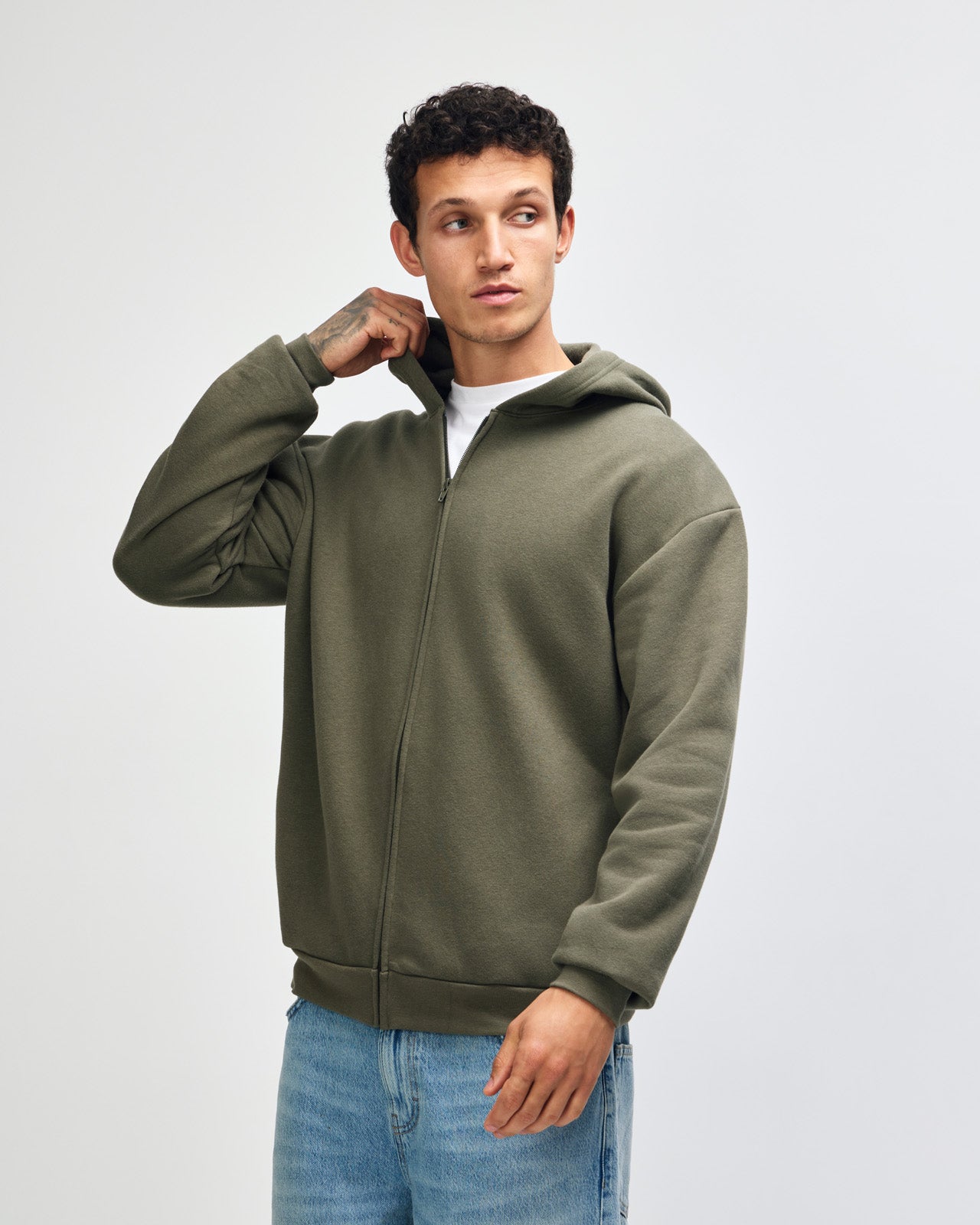 Male model wearing Reflex Unisex Full Zip Hooded Sweatshirt pairing with blue jeans (front pose) - lieutenant