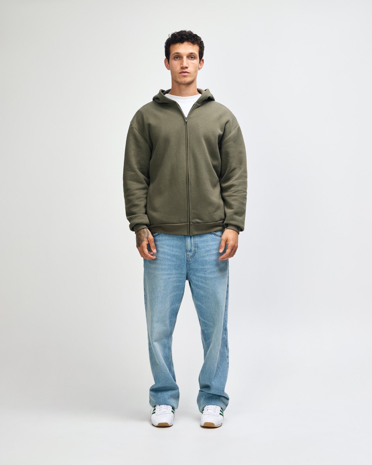 Male model wearing Reflex Unisex Full Zip Hooded Sweatshirt pairing with blue jeans (front pose) - lieutenant