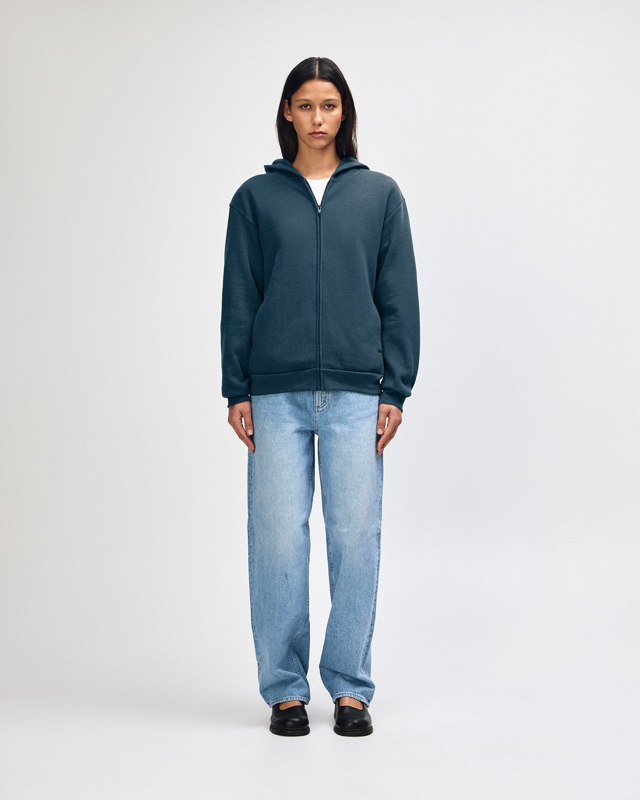 Female model wearing Reflex Unisex Full Zip Hooded Sweatshirt pairing with blue jeans (front pose) -sea blue