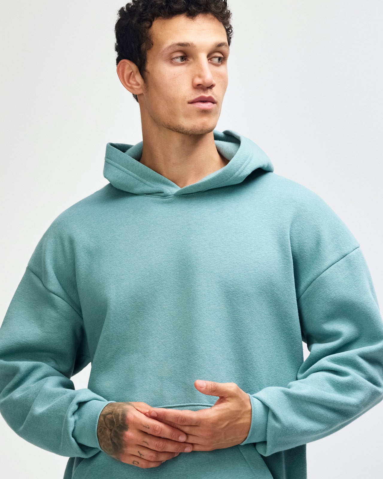 Male model wearing a Reflex Unisex Hooded Sweatshirt (front pose) -arctic
