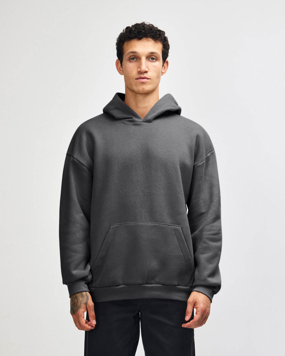 image of Pullover Hoodie  - Puff Logo : Person wearing a gray hoodie on a light gray background -Asphalt