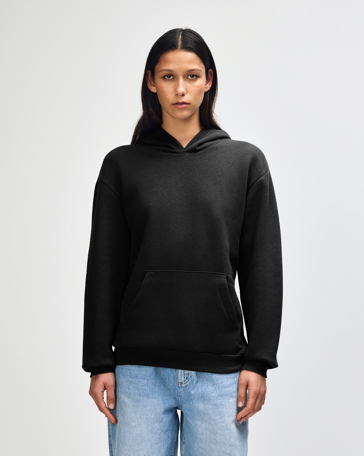 Female model wearing a Reflex Unisex Hooded Sweatshirt (front pose) -black