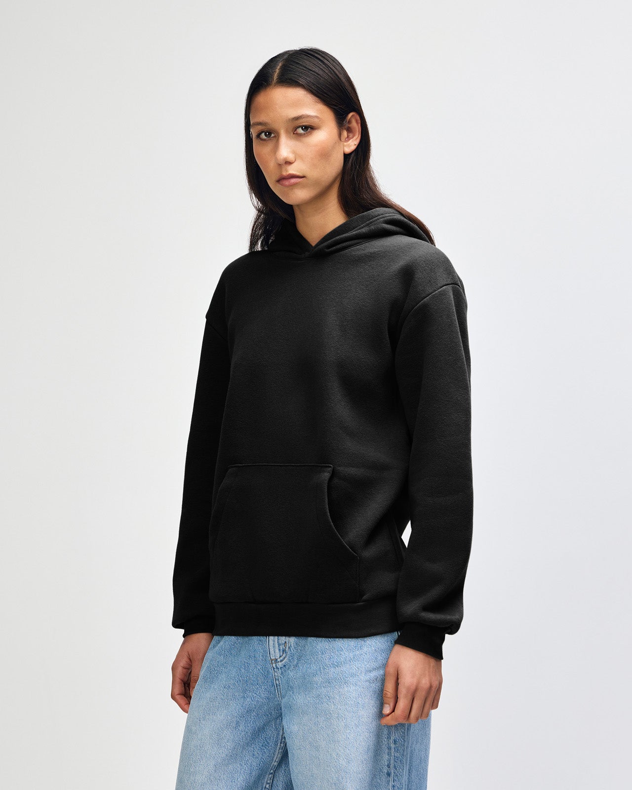 Female model wearing a Reflex Unisex Hooded Sweatshirt (front pose) -black