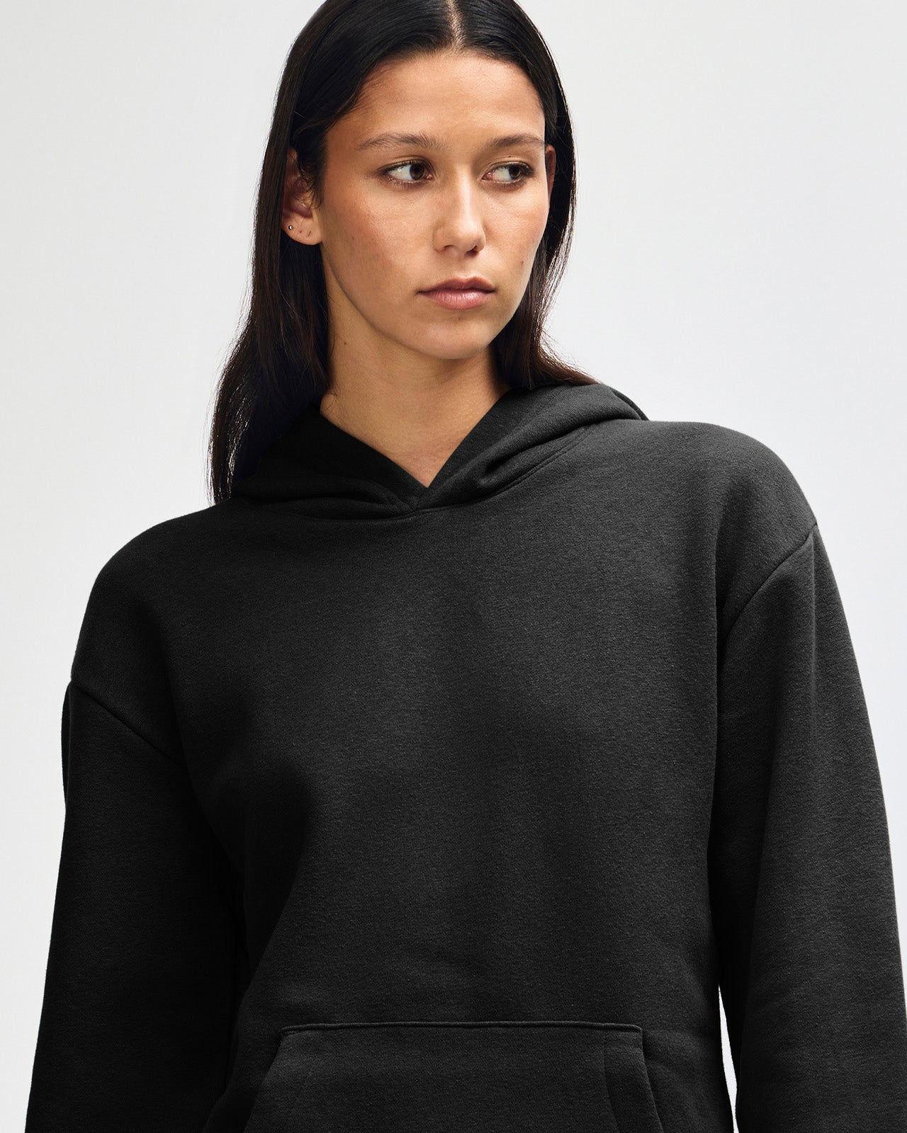 Female model wearing a Reflex Unisex Hooded Sweatshirt (front pose) -black