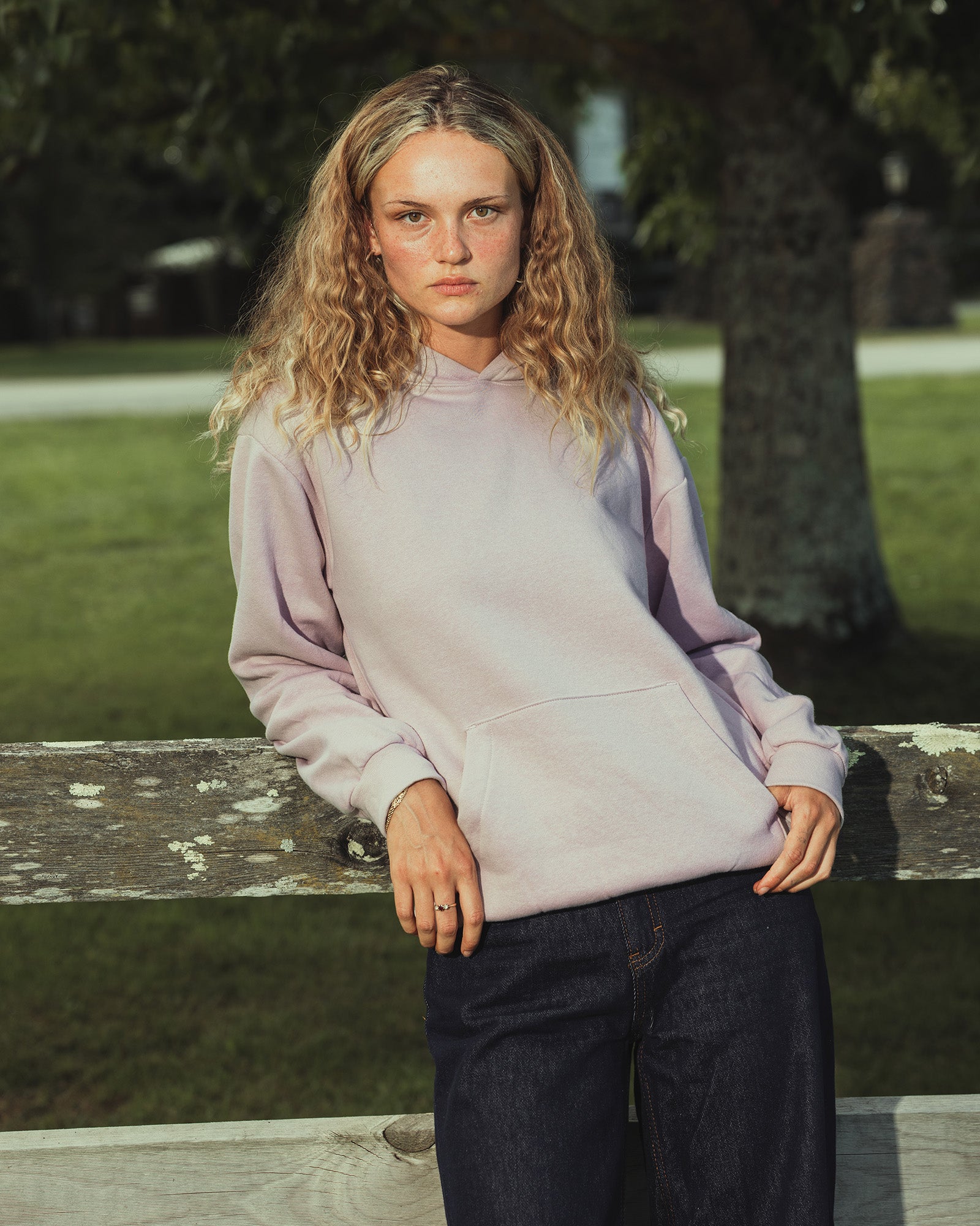 Female model wearing a Reflex Unisex Hooded Sweatshirt (front pose) - Blush