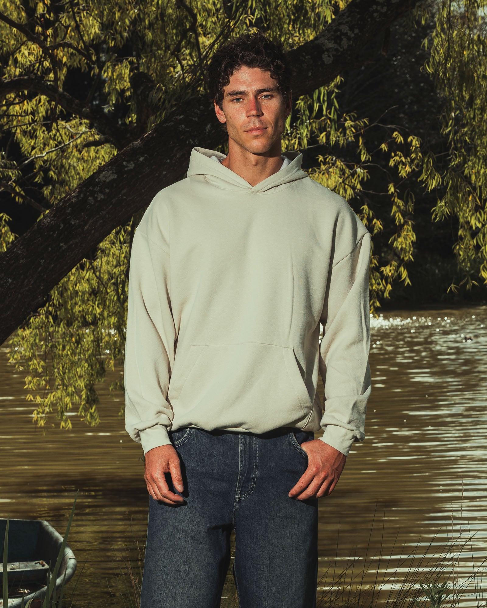 Male model wearing a Reflex Unisex Hooded Sweatshirt (front pose) -bone